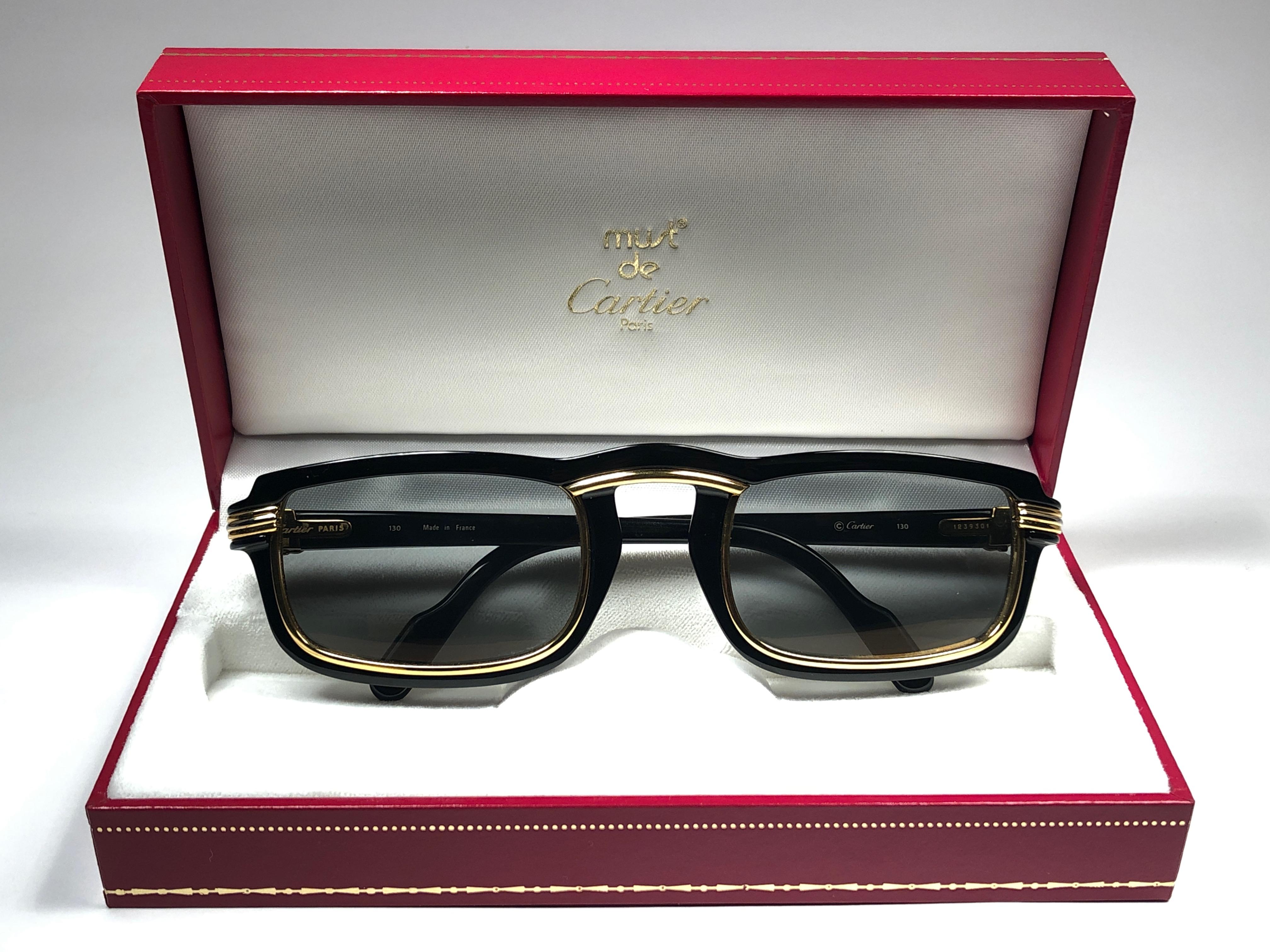  1991 Original Cartier Vertigo Art Deco Sonnenbrille mit erstaunlichen Grau Licht gespiegelt  (Uv-Schutz) Linsen.
Frame hat die berühmte Real Gold und Weißgold Akzente in der Mitte und an den Seiten.
Alle Markenzeichen. Cartier Goldzeichen auf den