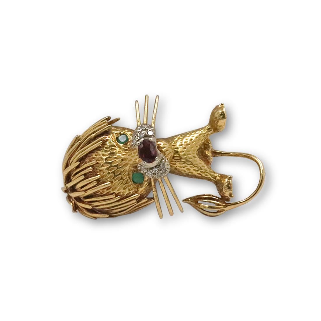 Authentic Cartier 'Whimsical Lion' brooch crafted in 18 karat yellow gold set with single cut diamonds weighing an estimated .05 carats total. This amusing brooch, designed as a playful lion with a tousled mane features a garnet nose and vibrant