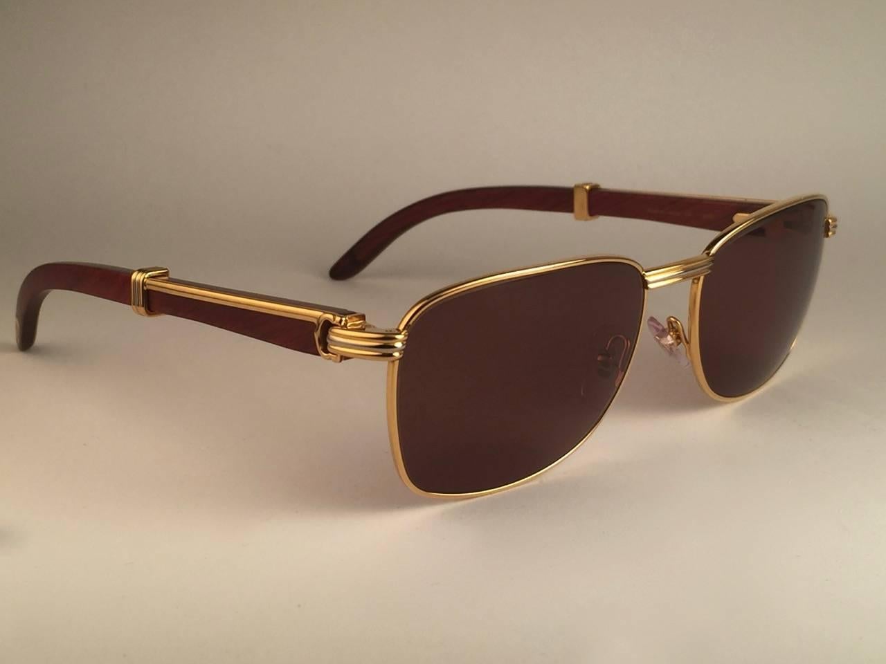 Vintage 1990 Cartier Full Set Amboise Bubinga Hardwood Sunglasses with new solid honey brown (uv protection) lenses. 
Le cadre est avec l'avant et les côtés en or jaune et blanc et a les célèbres temples en bois et accents d'or. 
Un travail