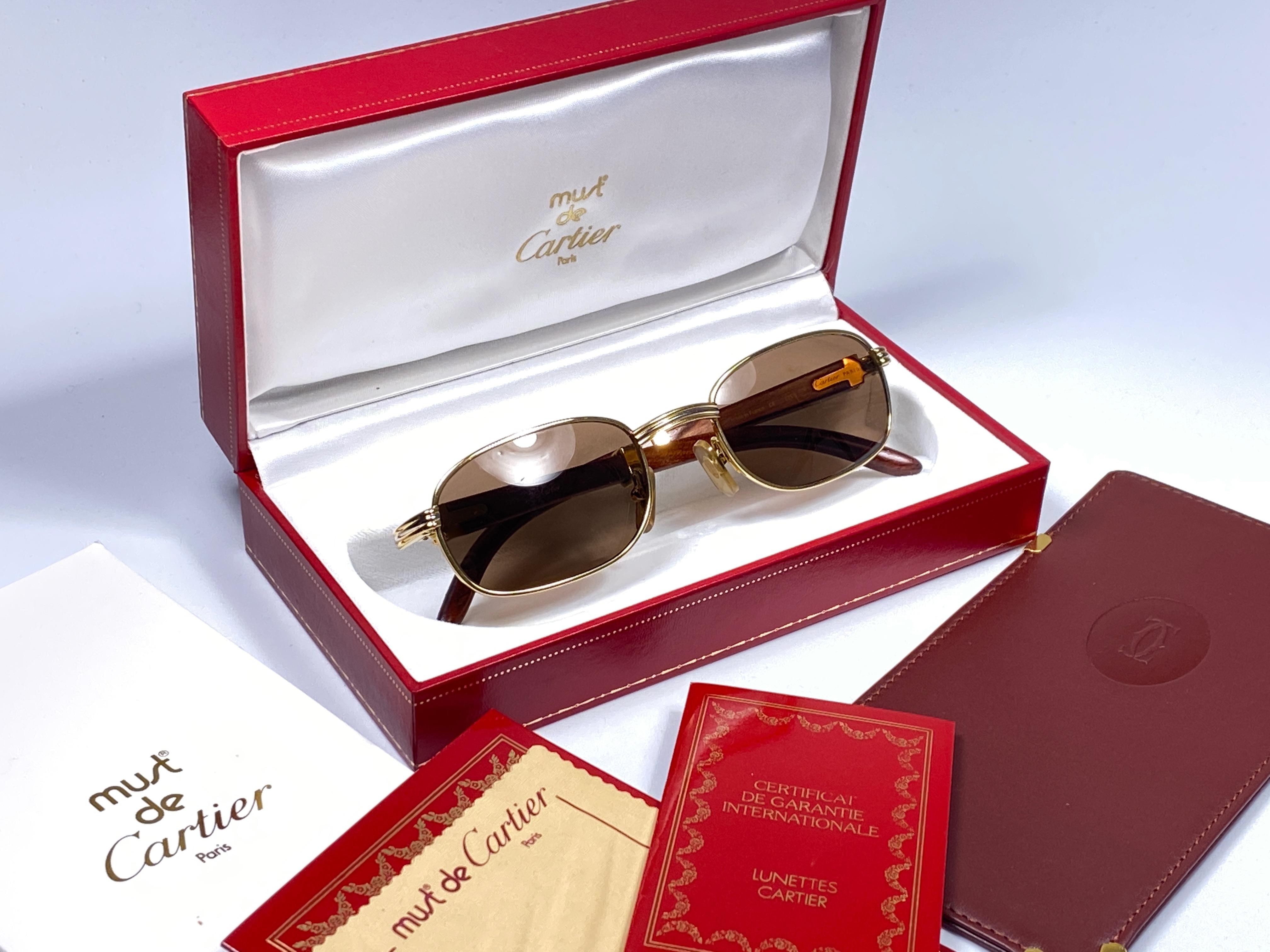New 1990 Cartier Full Set Breteuil Bubinga Hardwood Sunglasses with new solid honey brown (uv protection) lenses. 
Le cadre est avec l'avant et les côtés en or jaune et blanc et a les célèbres temples en bois et accents d'or. 
Un travail d'orfèvre !