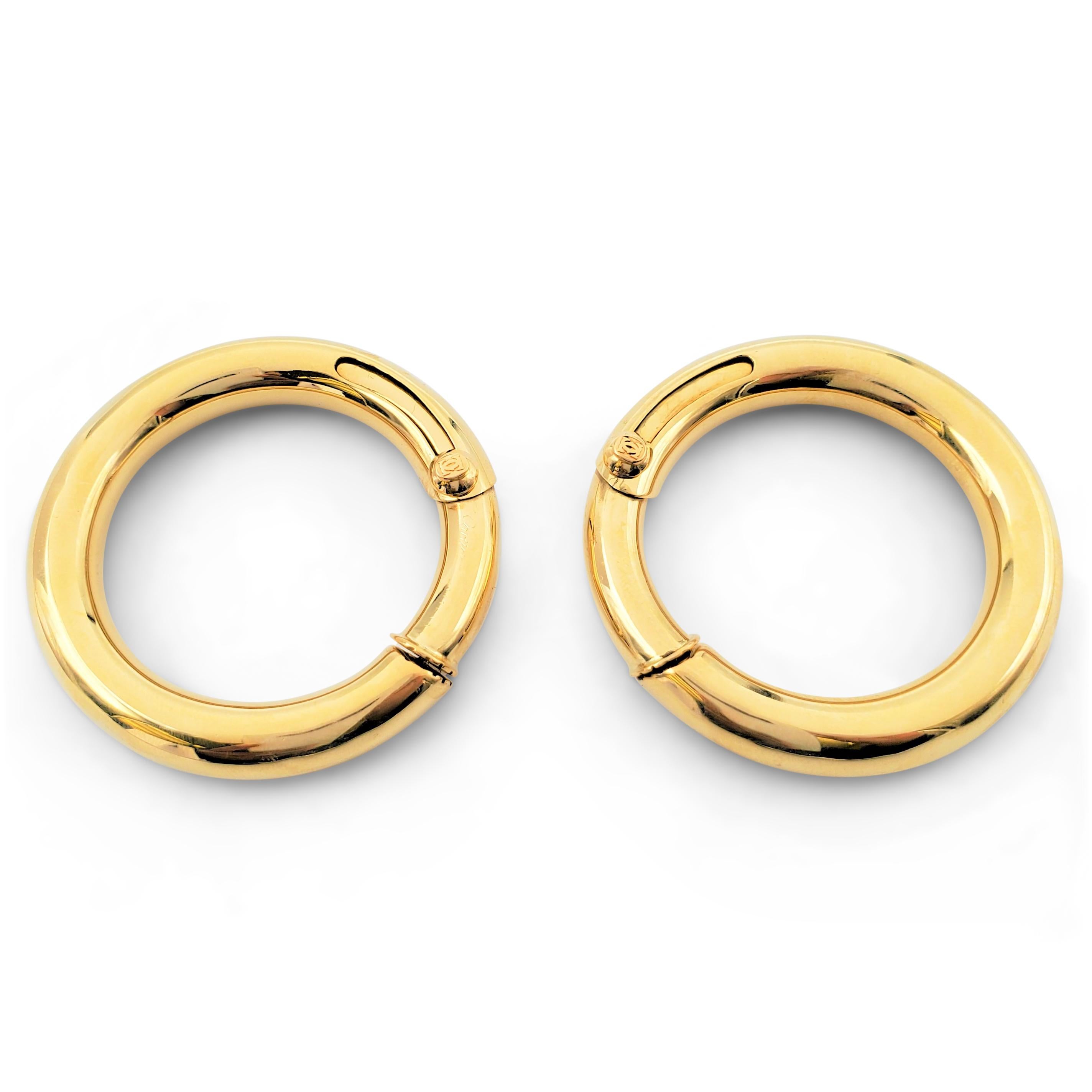 Authentic vintage Cartier hoop earrings crafted in 18 karat yellow gold feature a sliding cover hidden post. Signed Cartier, 750, with serial number. Both the signature and serial number are rubbed. Not presented with the original box or papers.