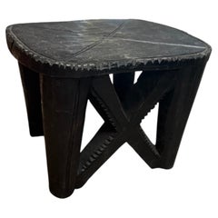 Taburete vintage de madera negra africana tallada con diseño en forma de «X»