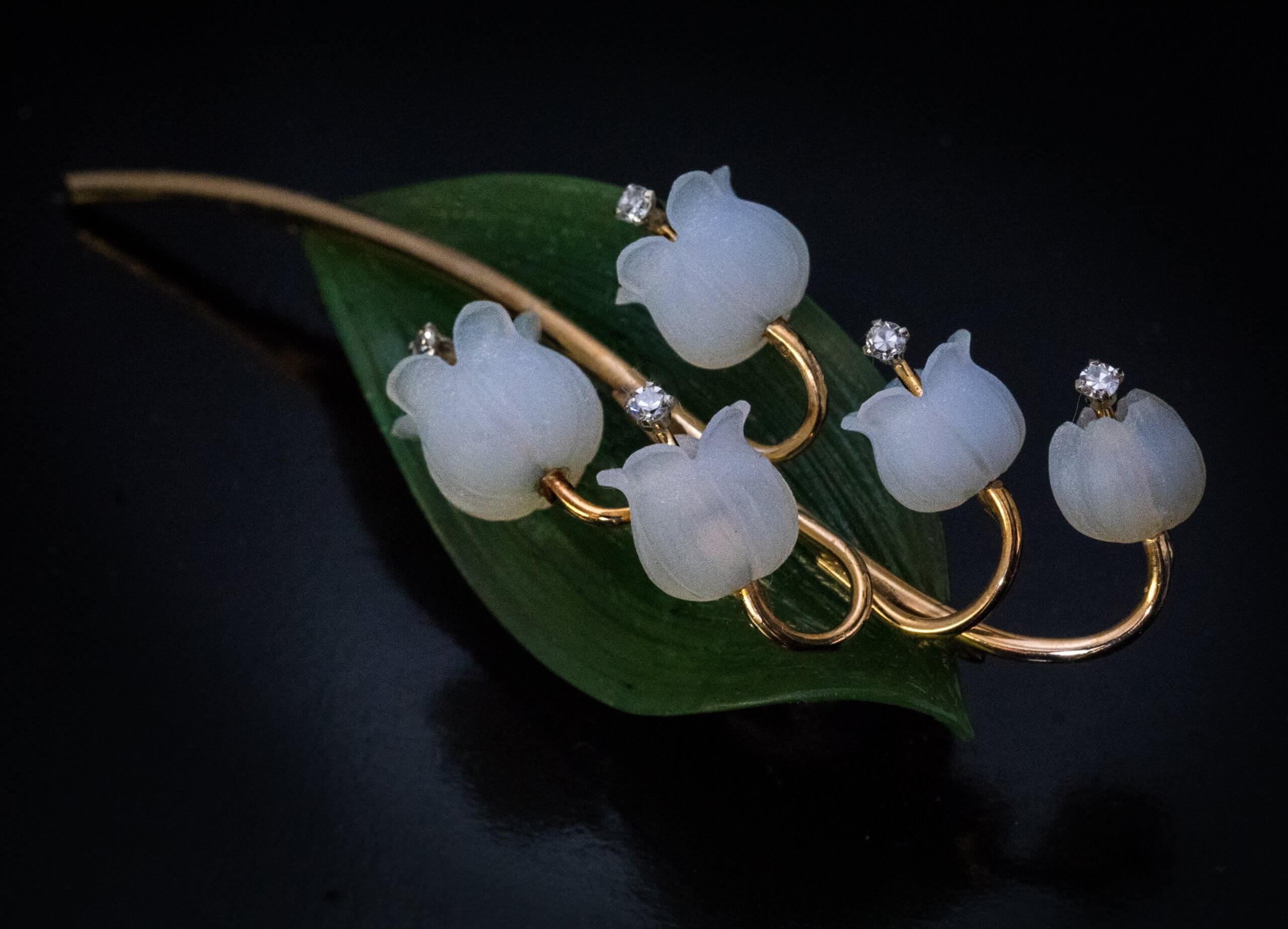 Made in Vienna, Austria in the 1950s.  The brooch is finely modeled as a lily of the valley. The flower heads are superbly carved from frosted agate and embellished with small diamonds. The green leaf is naturalistically carved from a single piece