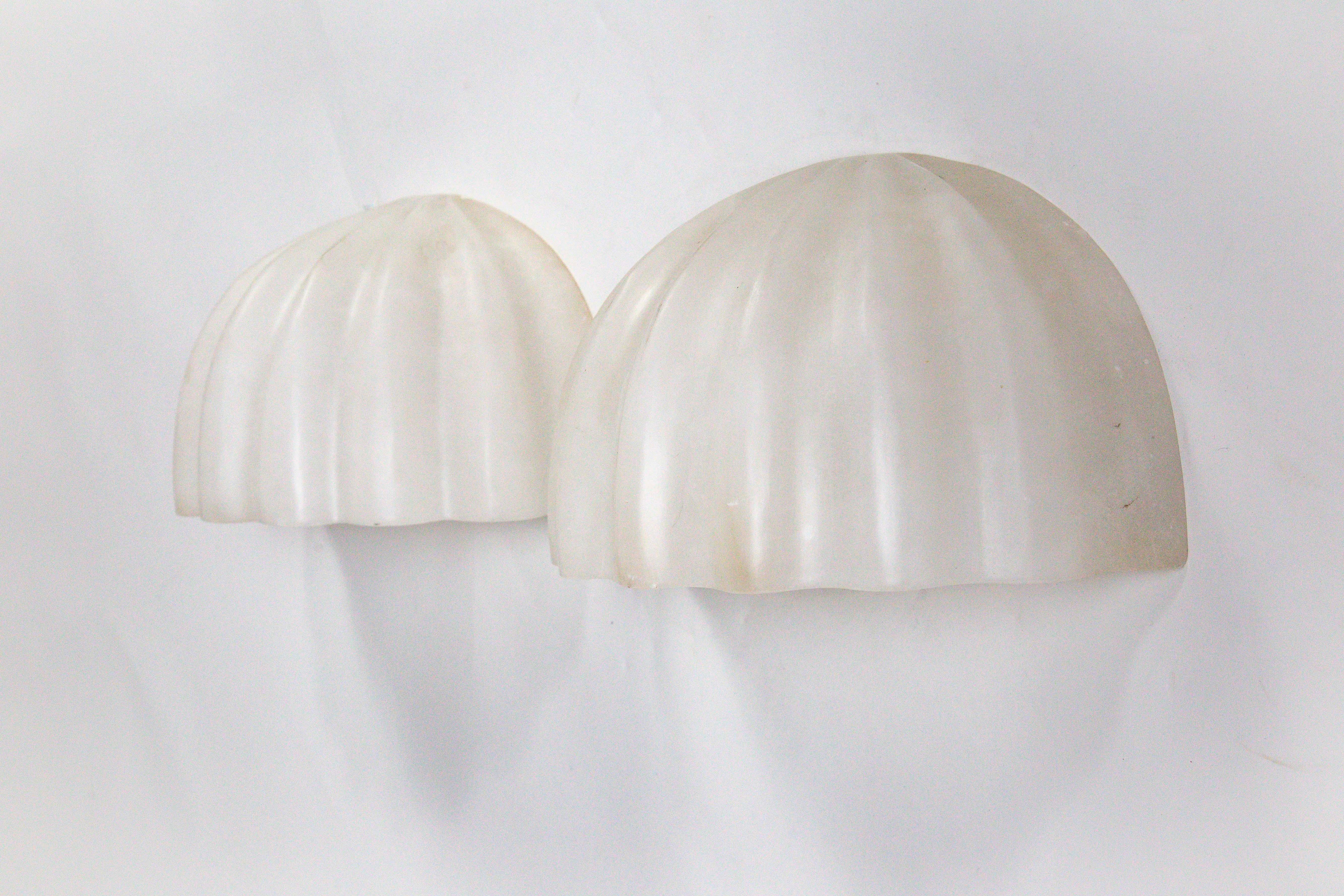 A pair of vintage carved alabaster shell form sconces with a gorgeous look and feel. The look great pointed up or down, with a beautiful tone both lit and unlit. Made by Boyd Lighting Company in the 1980s. American. One porcelain, medium base socket