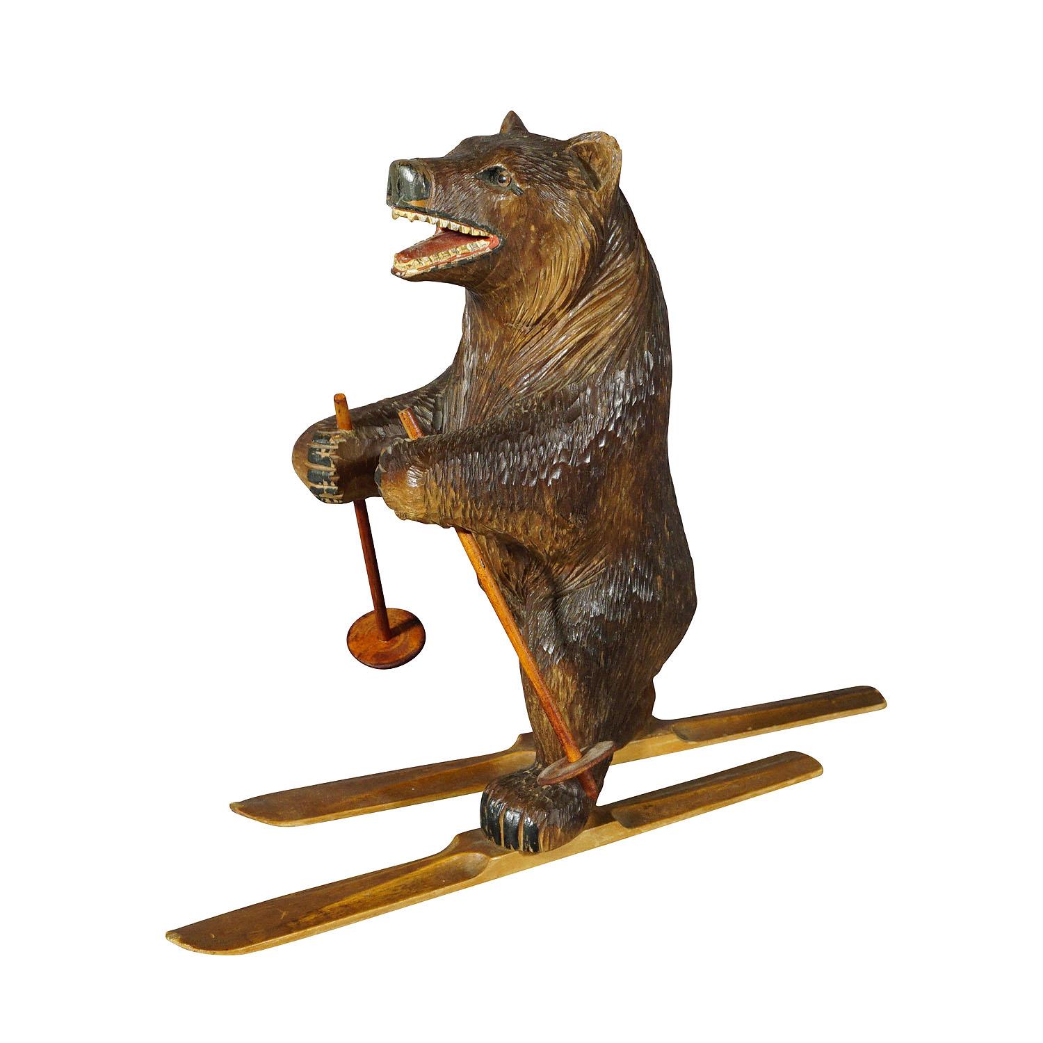 A rare wooden carved sculpture featuring a skiing bear. Handcarved in lindenwood with naturalistic details in the area of Brienz, Switzerland ca. 1930. This large Swiss Black Forest carved sculpture would be a stunning addition to any room or desk.