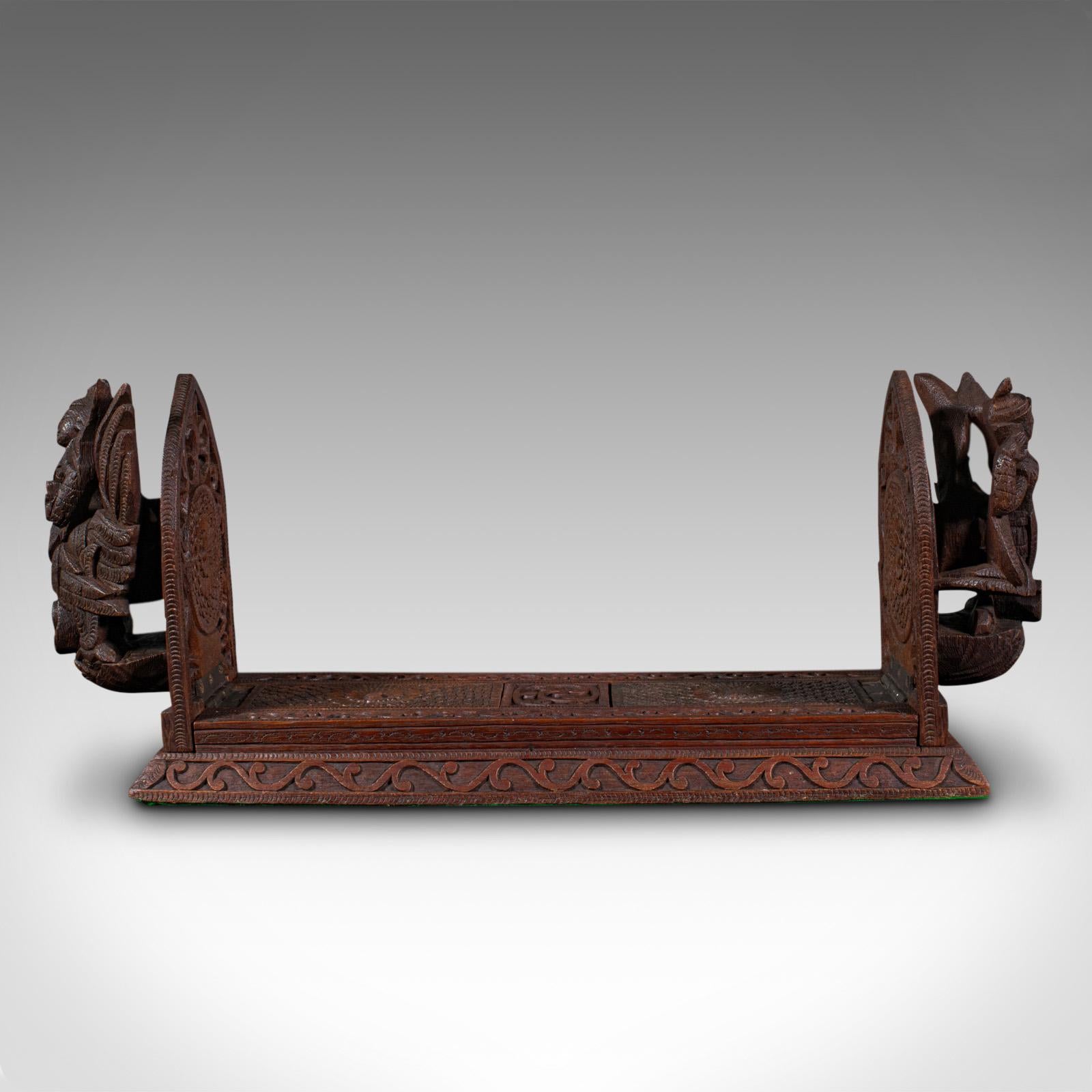 This is a vintage carved book slide. A Balinese, hardwood library stand, dating to the mid 20th century, circa 1960.

Fantastic mid-century exotic book slide with striking carved figures
Displays a desirable aged patina and in good