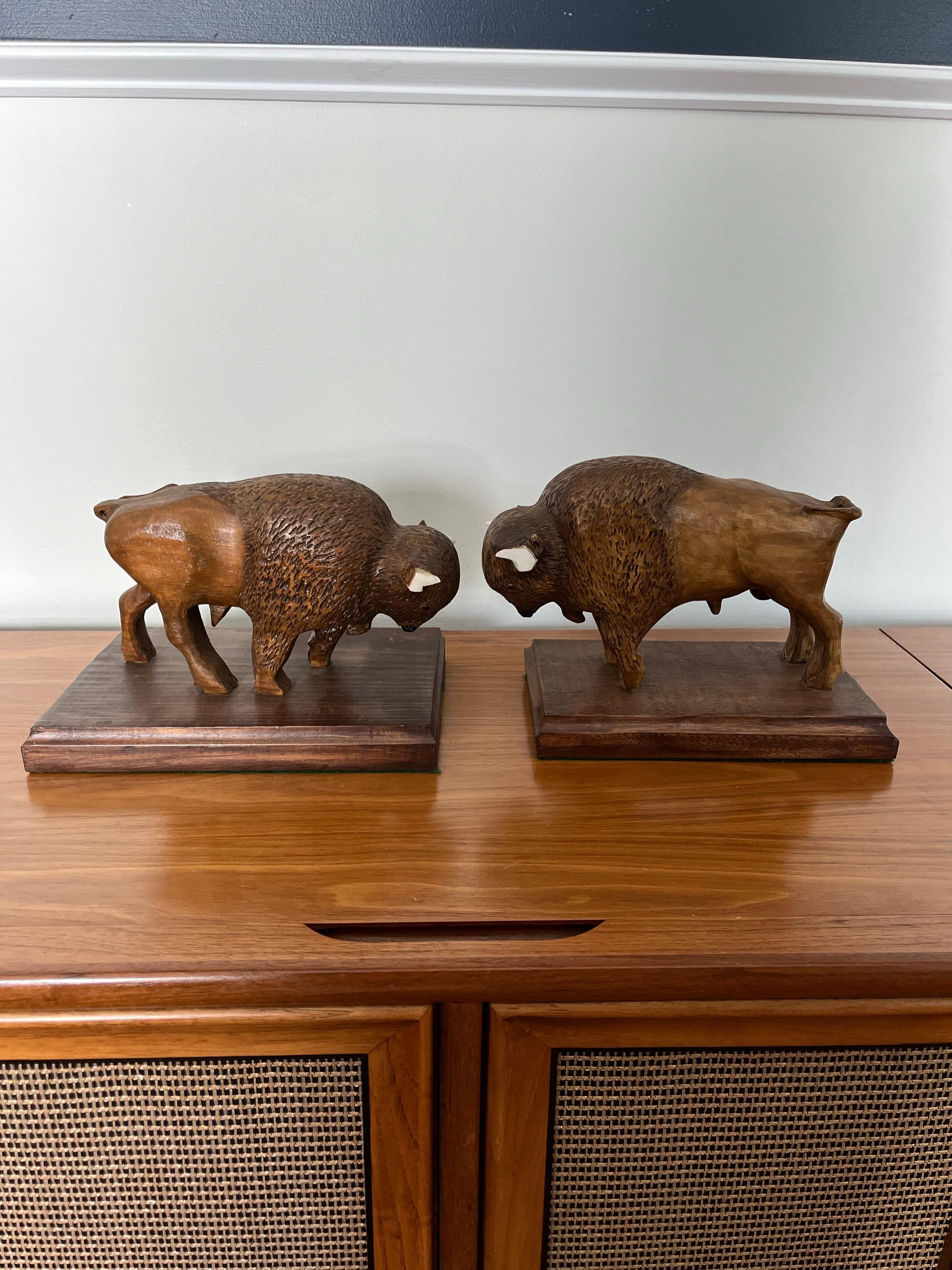 Fantastica coppia di bufali o bisonti scolpiti a mano in legno. Ottimi dettagli e proporzioni. Le dimensioni sono leggermente diverse. Firmato SL Mitchell