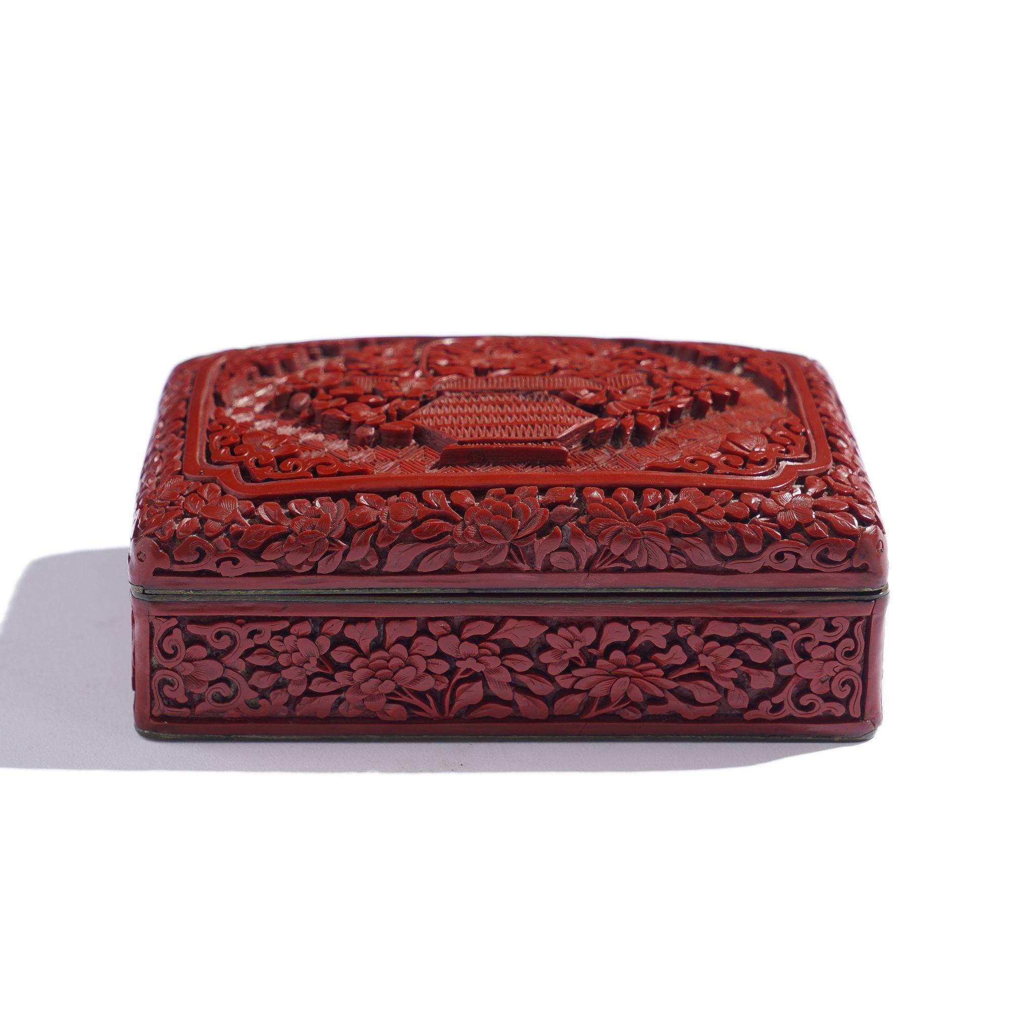 Vintage Chinese carved cinnabar lidded box with black enameled interior. The carved lid centers on a basket of flowers on a patterned field within a framed reserve.