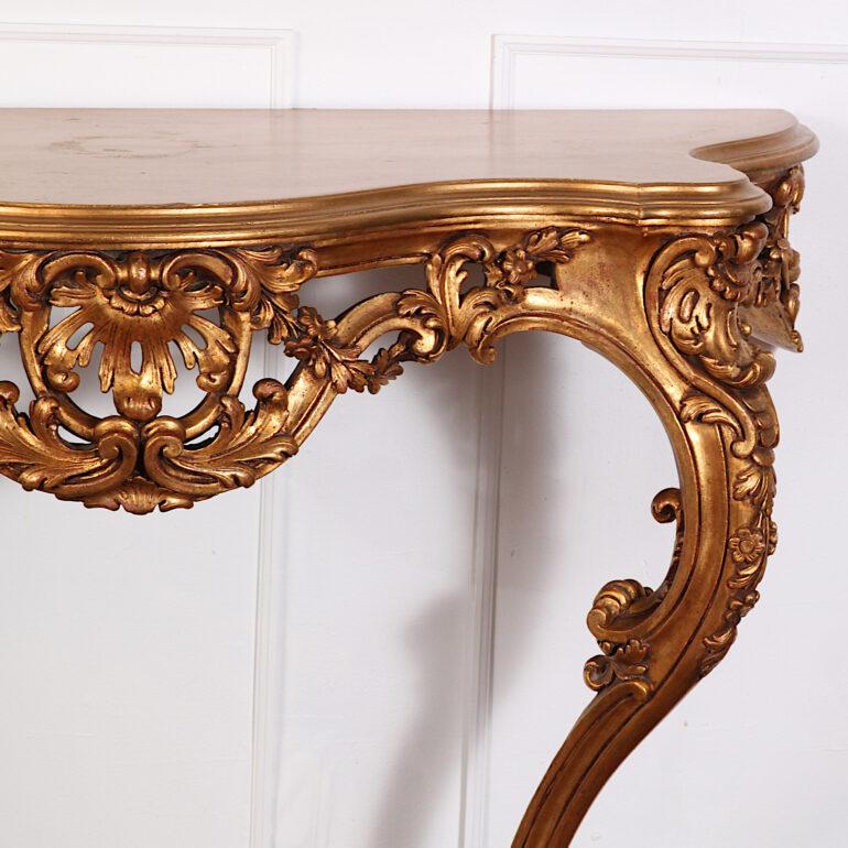 Louis XV style carved and gilded console of serpentine form, having a lavishly pierce-carved apron and standing on elegant carved cabriole legs with scrolled feet.


 