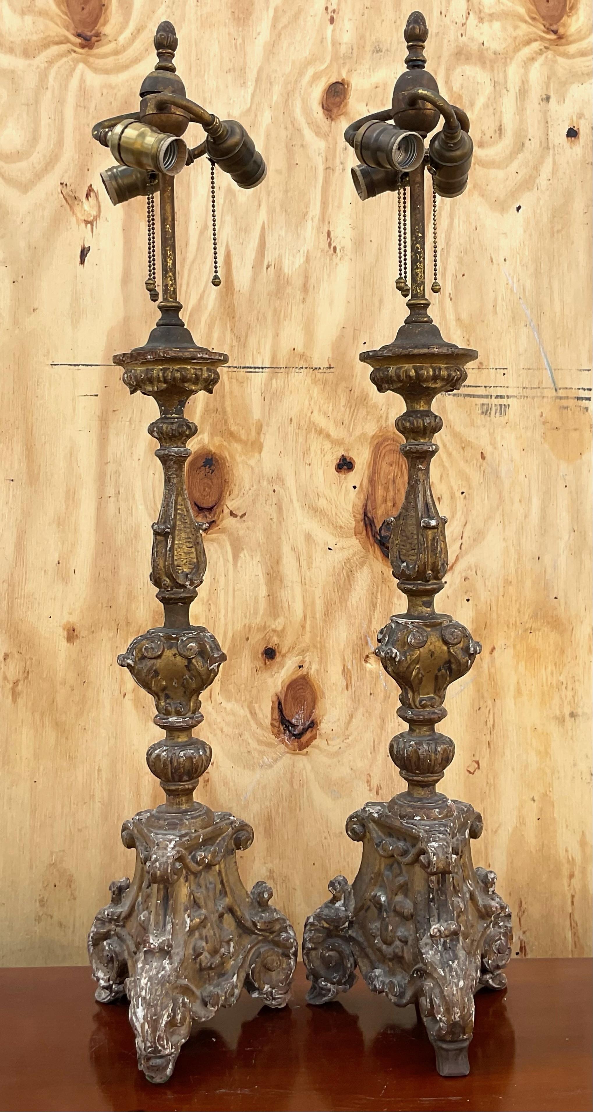 Spectacular vintage pair of carved gilt table lamps. These incredible lamps have three bulbs all operated with their own pull string. Their intricate detailing matched with their scale make them the perfect statement piece you have been searching