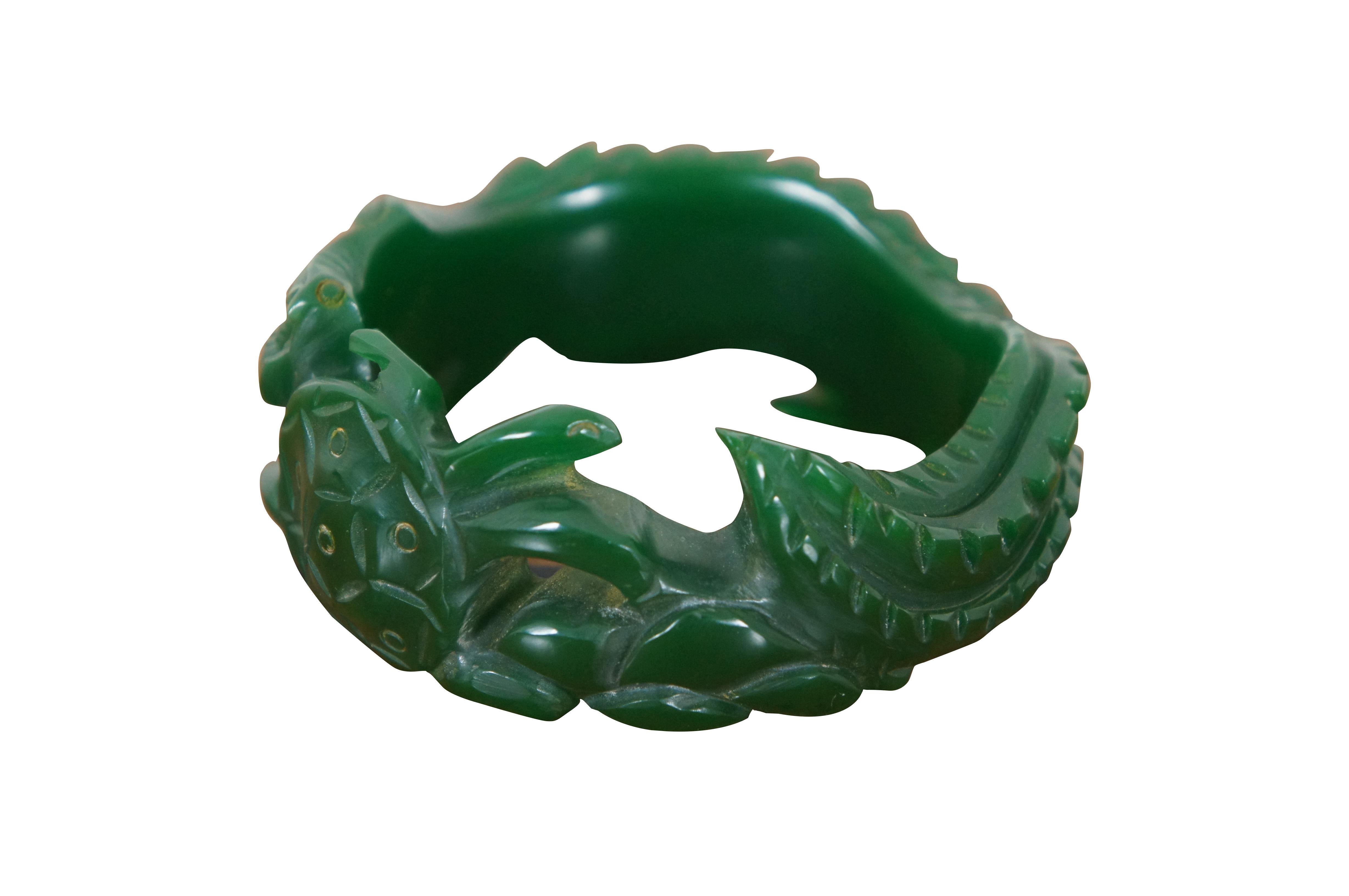 Early to mid 20th century green Bakelite bangle bracelet, beautifully carved in the weaving shape of a crocodile / alligator chasing a sea turtle. Swab tested by previous owner.

Dimensions:
8” x 0.375” x 1.25” (Width x Depth x Height)