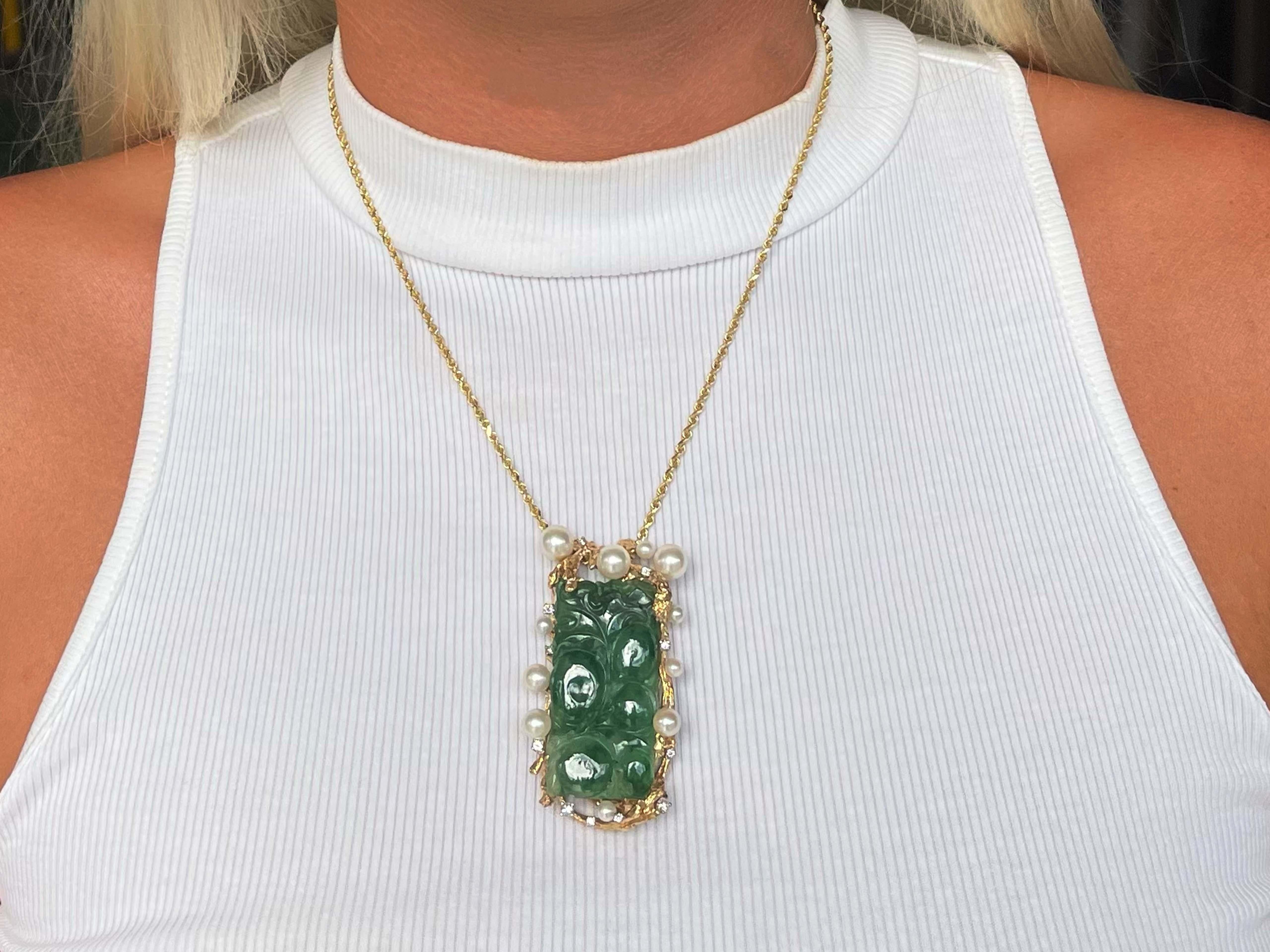 Vintage Carved Green Jadeite Jade Diamond and Pearl Pendant in 14k Yellow Gold. Large rectangular shape beautifully carved and pierced green jadeite jade randomly surrounded by  Diamonds and pearls. The Jade measures approximately 43 mm x 22 mm x 5