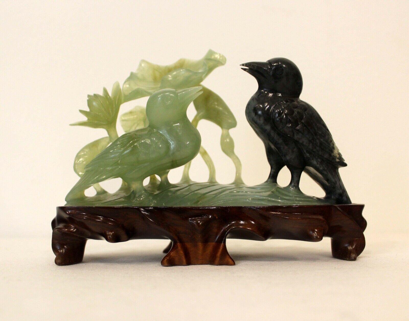 Incredibly carved Jade birds with Lotus flowers. Artisan sculpted piece to take advantage of the Dark green portion of the Jade to to give definition to the 
second bird. Includes carved attached base specific to the piece.
Dimensions: 7.5 W x 3 D