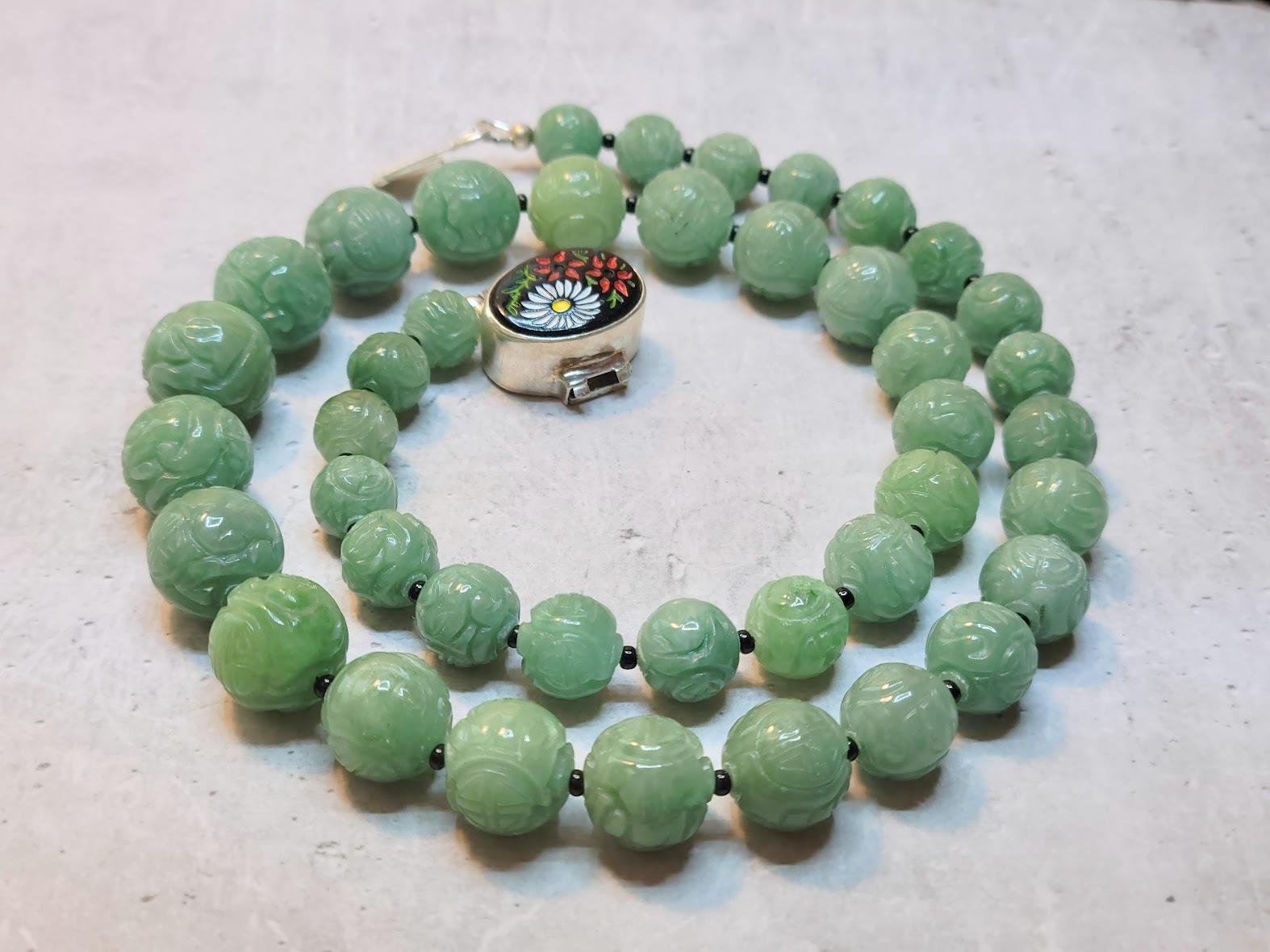 A gorgeous necklace of old green jade beads and vintage tiny seed glass beads with a vintage, unique silver clasp. The shou symbol & floral motif are carved in the beads. The shou represents longevity.

The length of the necklace is 20.5 inches (52