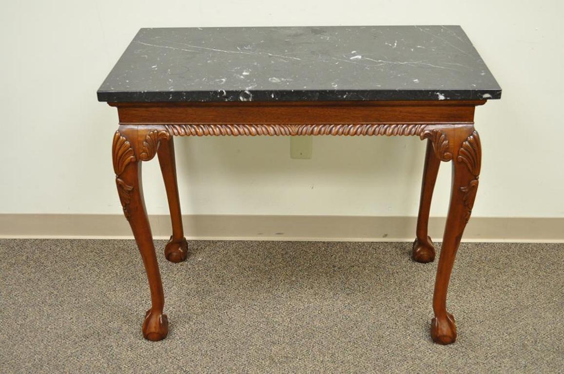 Quality carved solid mahogany Chippendale style marble-top console / hall table. Item features shapely legs with shell carved knees terminating at ball and claw feet, rope carved front skirt, finished back with non-rope carved rear skirt,