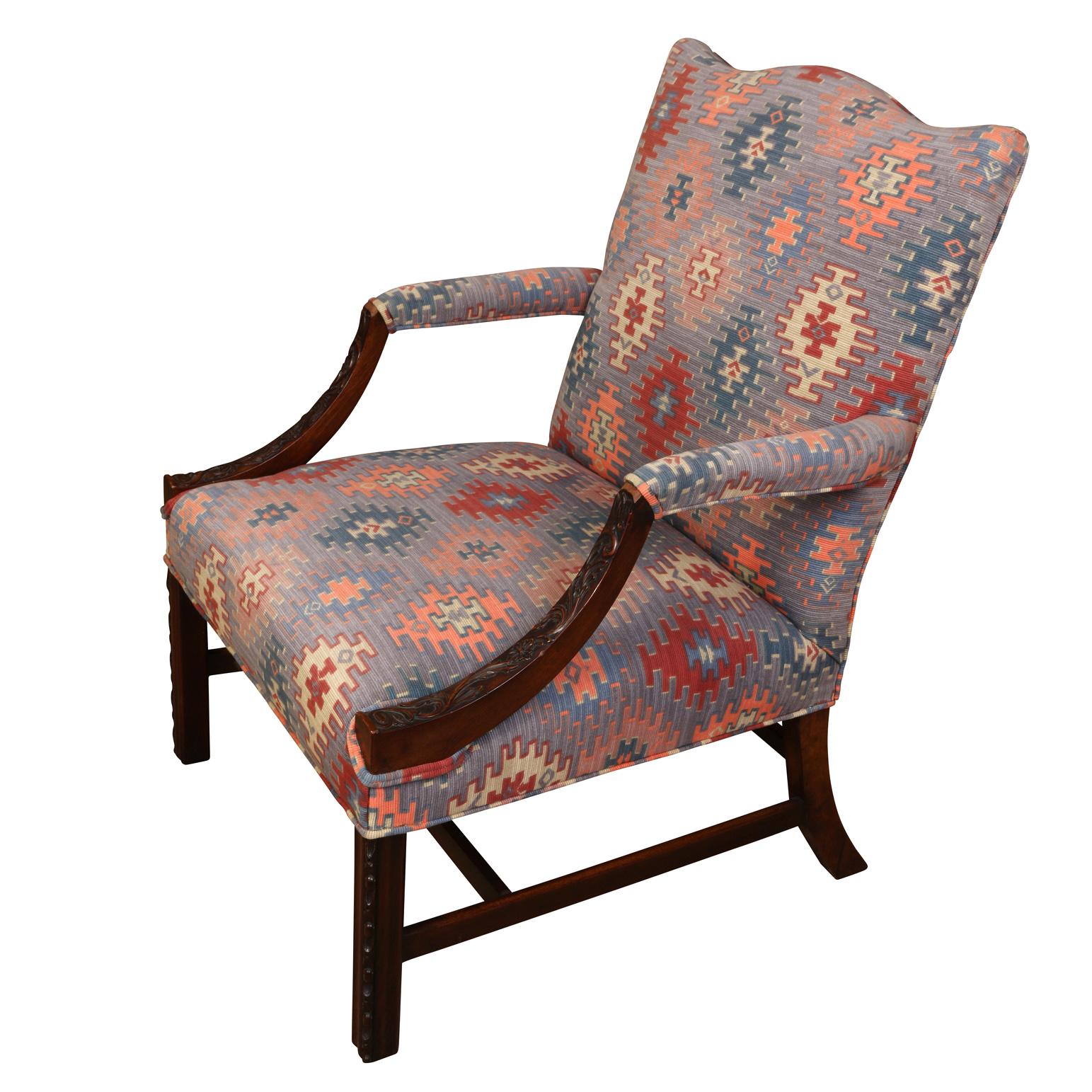 Une chaise de bibliothèque de style George III avec des bras sculptés en acajou, des pieds droits et un dossier façonné. Tapissé d'un motif kilim ikat bleu, rose et saumon.
