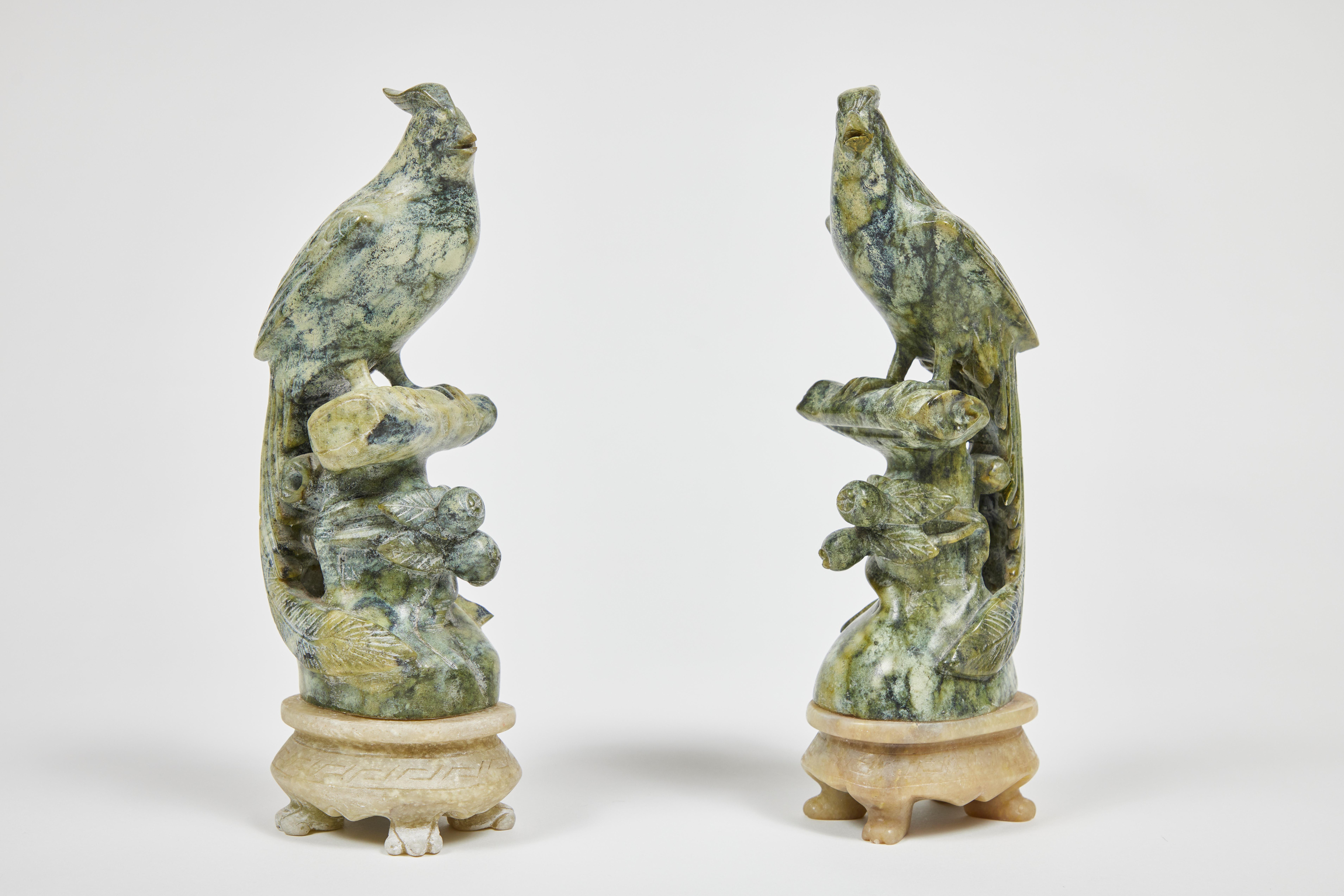 Fabulous pair of vintage carved mottled green stone parrots perched on a sold green stone footed base.

Each sculpted parrot measures 10.75