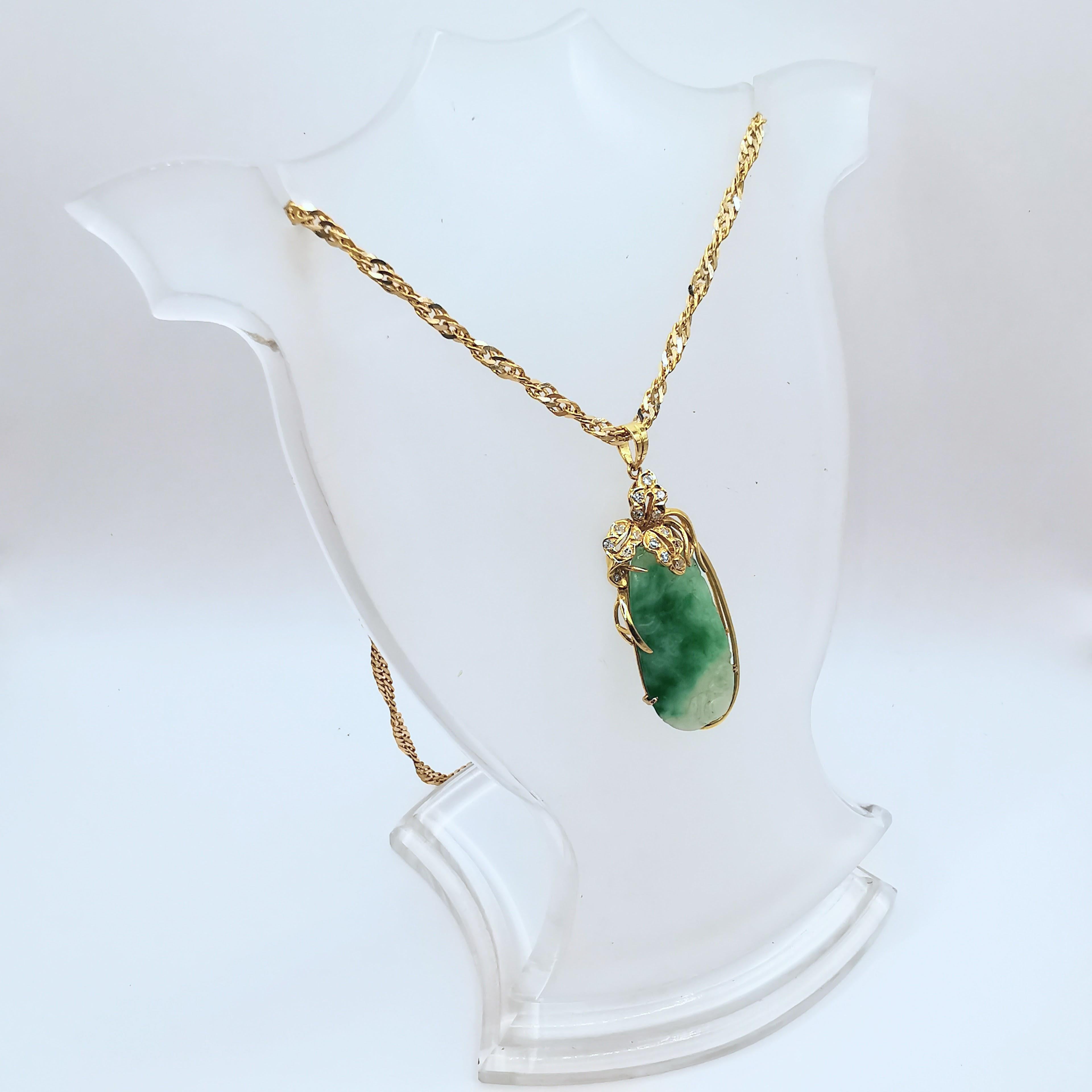 Introducing our stunning Vintage Carved Natural Jadeite Jade and Diamond Pendant, crafted in 14K yellow gold. The pendant features a translucent green on white jadeite jade, intricately carved with a unique vintage design. The jadeite jade is a