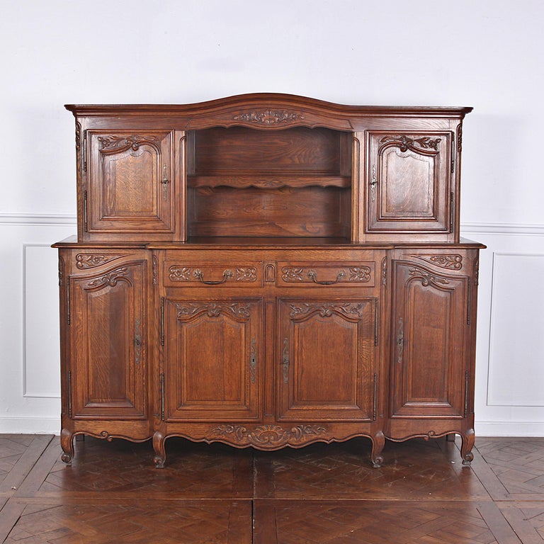 Beautifully hand carved oak vintage French Louis XV style buffet with removeable top. Buffet base with four solid oak paneled / carved doors and two central drawers; upper piece with open shelf flanked by cabinets.