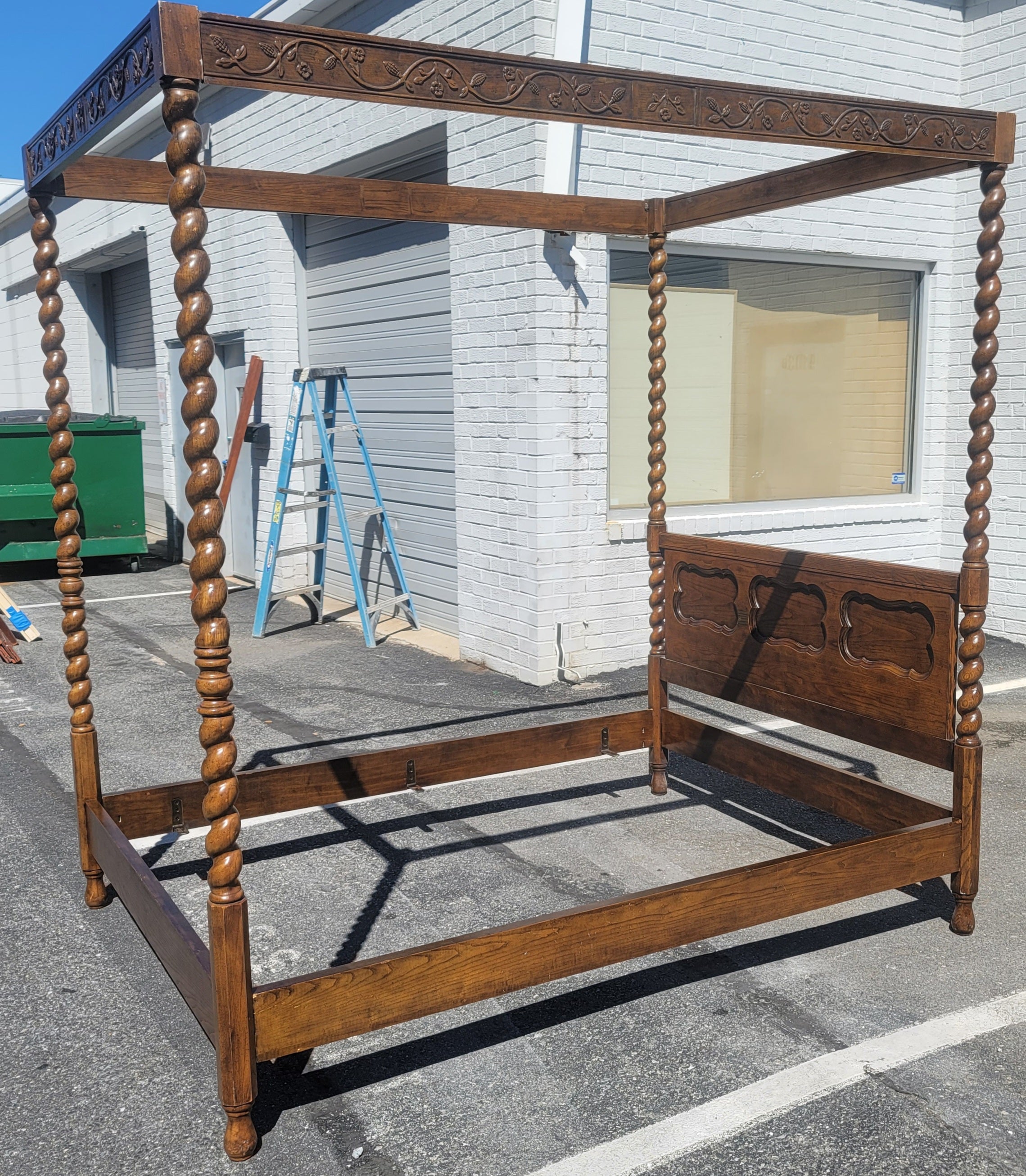 A gorgeous Vintage Carved Oak Canopy bed with Barley Twist Posters. Flower and branches wood carvings on 4 sides of the canopy. Attached brackets to side rails support the box spring. Panelized headboard. Bed Measures 85.5