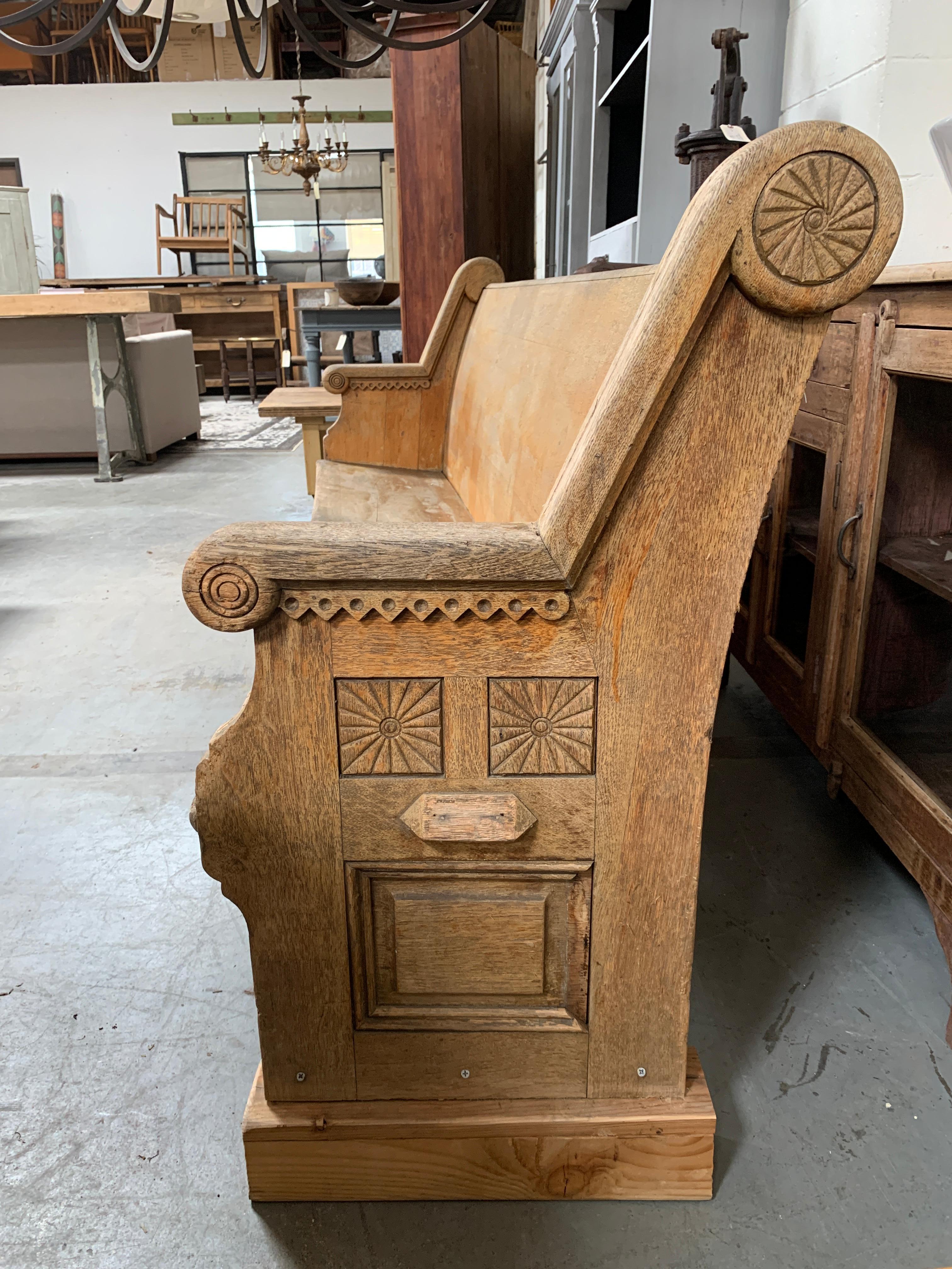 Genuine wooden church pew, featuring carved details on the arms. High, slightly arched back and lightly sloped seat showcase a piece designed for comfortable seating. Minor repair on right leg. 

Dimensions: 86