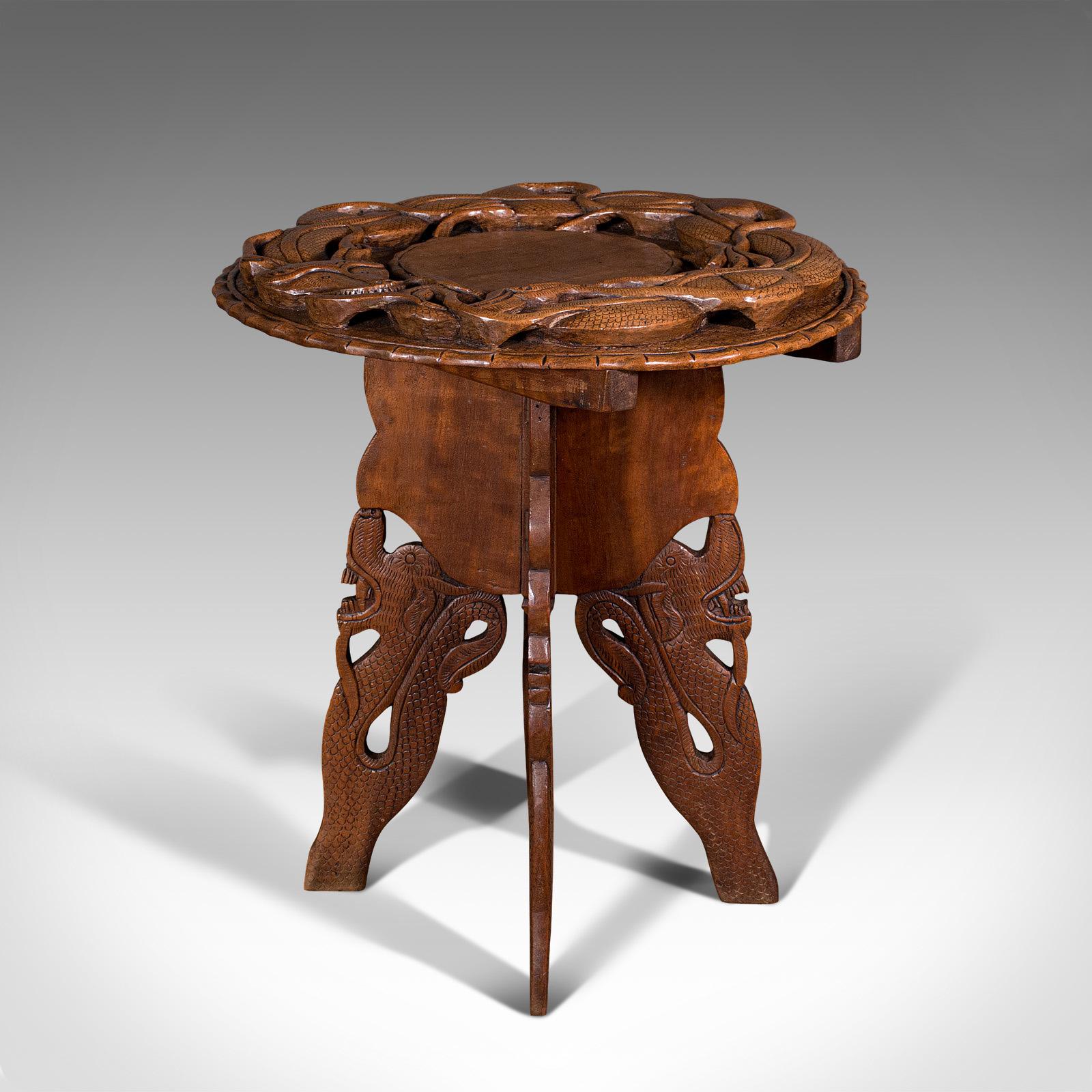 This is a vintage carved occasional table. A Chinese, elm fold away side or lamp table in Art Deco taste, dating to the mid 20th century, circa 1940.

Superb carvings abound to this delightful small table
Displays a desirable aged patina and in