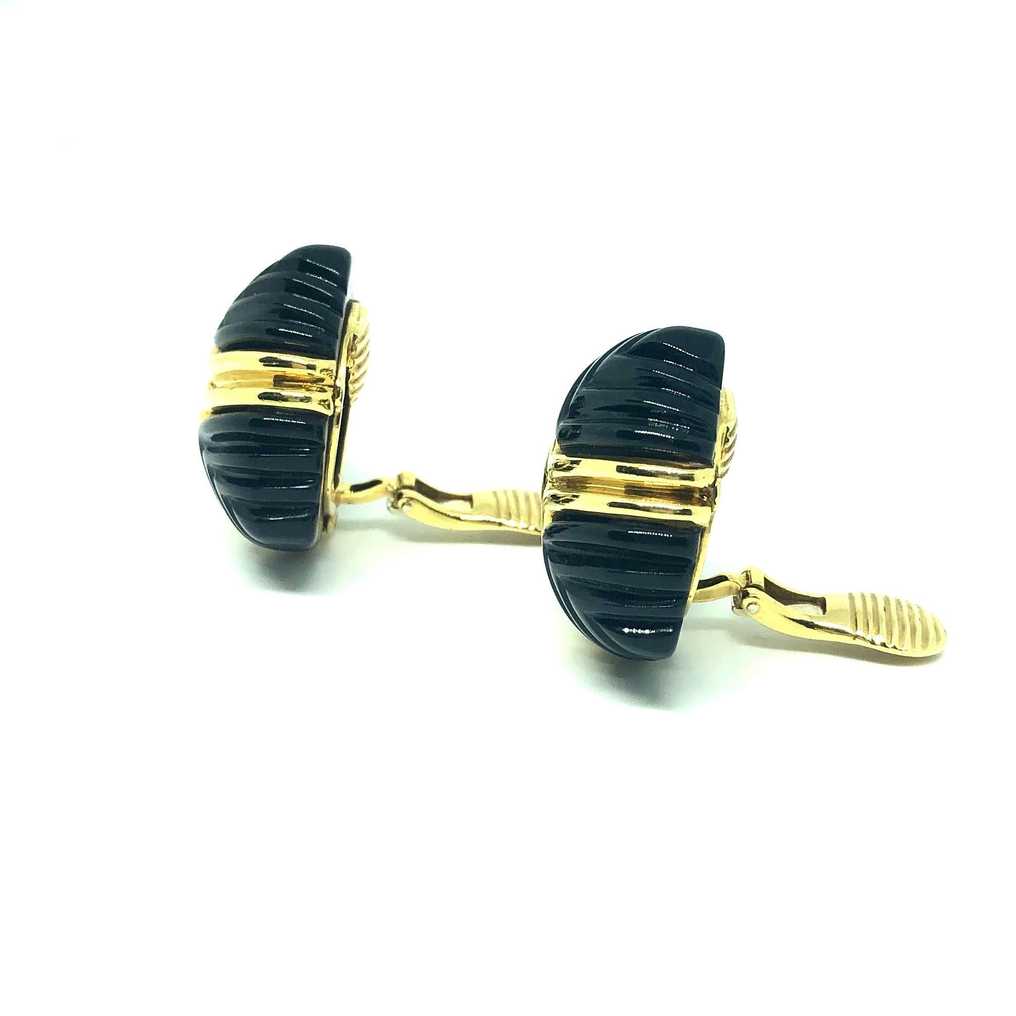 Large carved black onyx and 18K yellow gold clip-on earrings with a domed stylized chevron design. 
Each earring measures: 1 inch W x 1 1/16 inch H x 9/16 inch D
Weight: 30.4 grams
