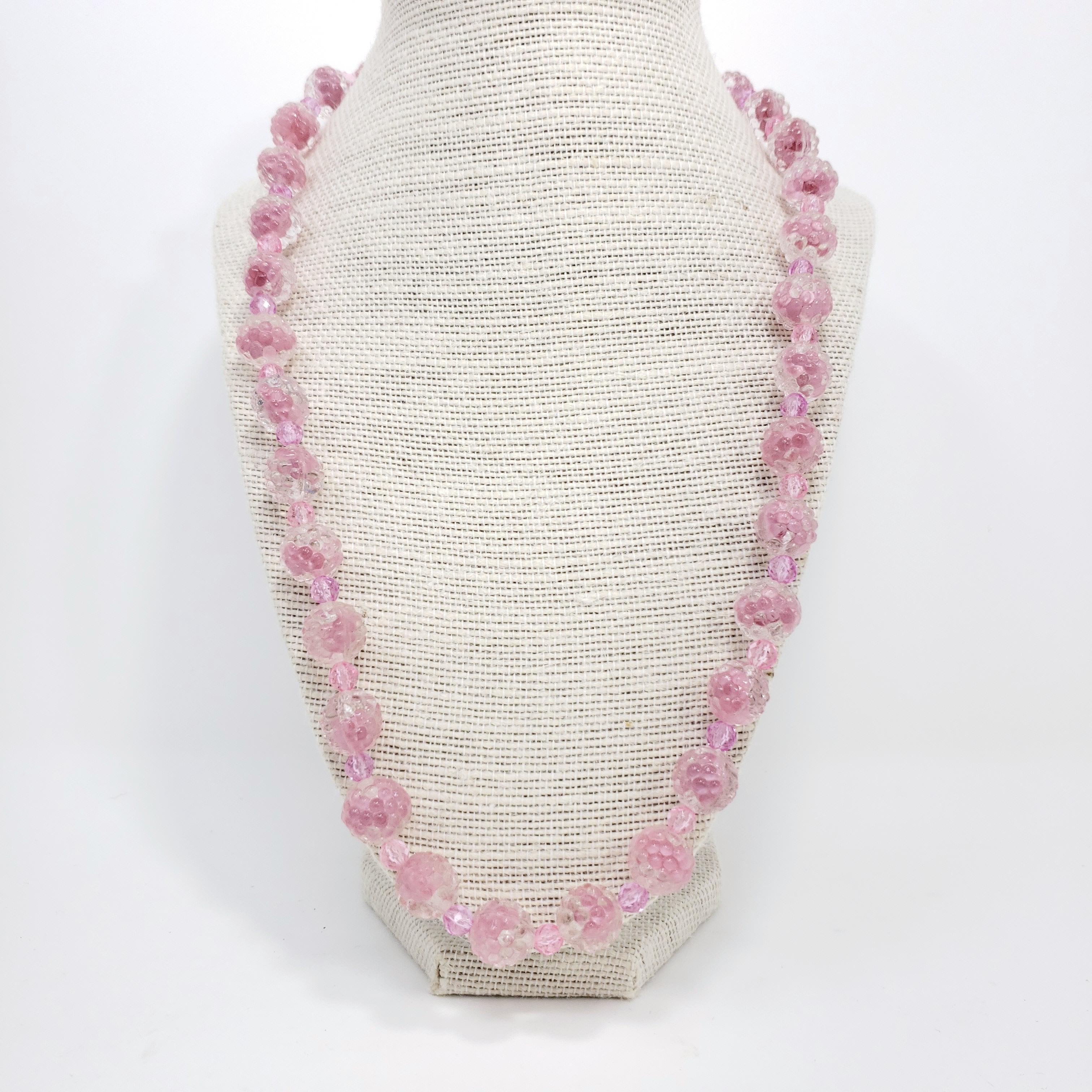 Carved pink and clear crystal necklace for just the right touch of retro glamour!

Brass-tone spring-ring clasp.