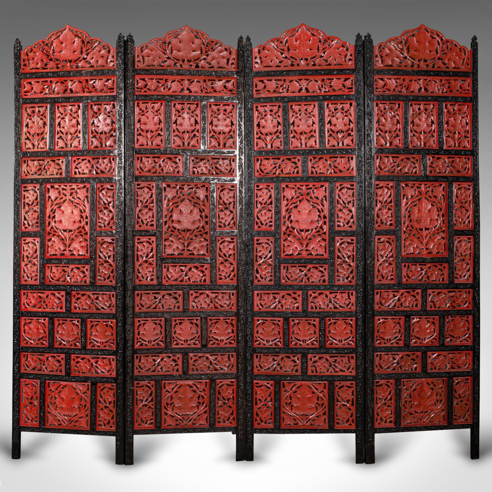 This is a vintage carved privacy screen. A Chinese, painted mahogany four panel room divider, dating to the late Art Deco period, circa 1940.
 
Profusely hand-carved privacy screen with striking red and black hues
Displays a desirable aged patina