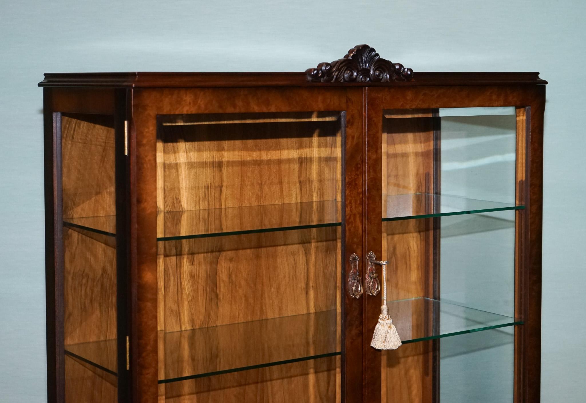 
Antiquités de Londres



Cette exquise vitrine vintage met en valeur l'élégance de l'artisanat de style Queen Anne. En placage d'acajou, cette pièce est ornée de détails complexes sculptés à la main le long du tablier et des pieds, ainsi que de