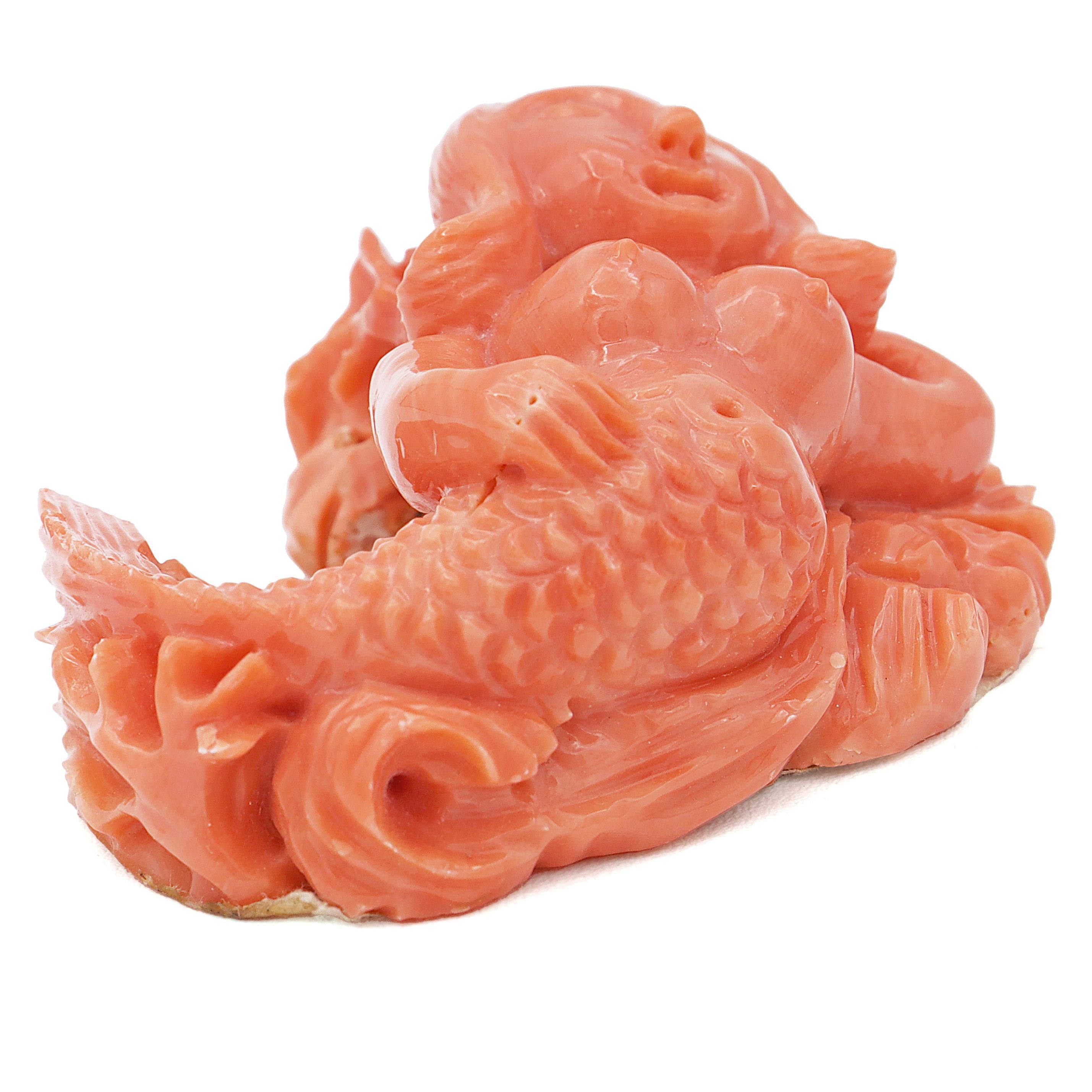 A mesmerizing loose stone sculpture masterfully carved from vibrant red coral, depicting a gracefully detailed mermaid. Every element, from the intricately sculpted scales to the flowing, lifelike hair, reflects exceptional artistry. This