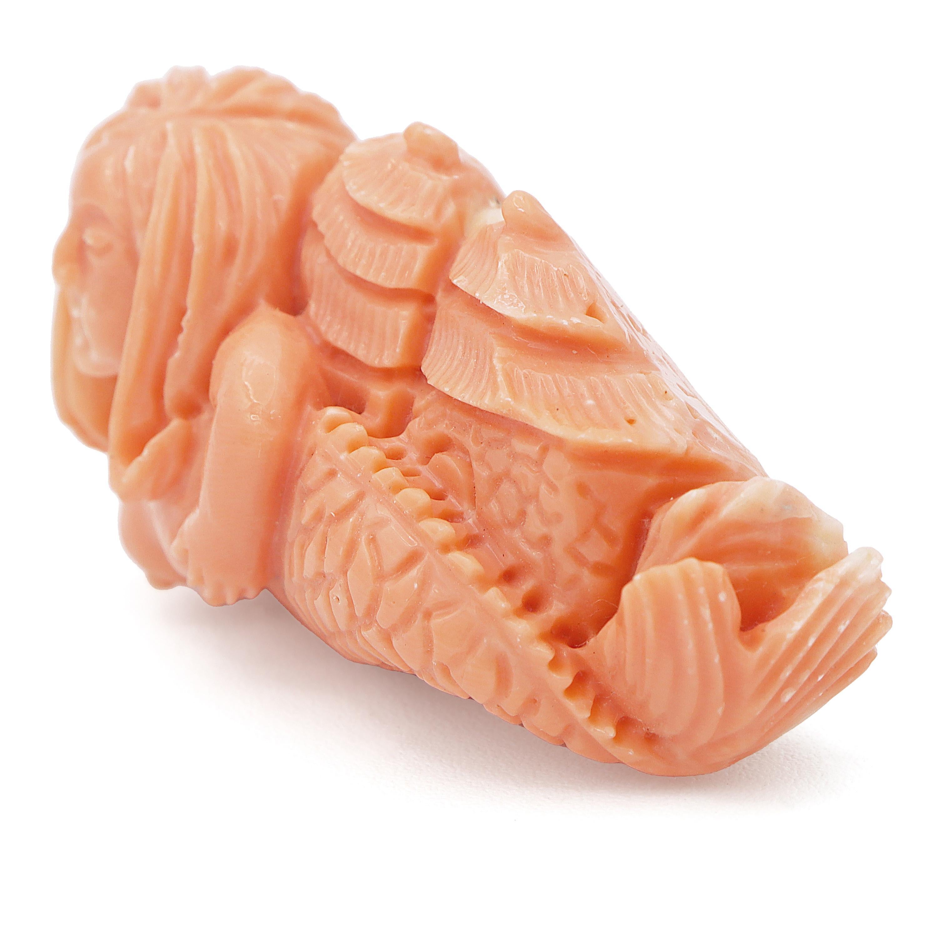 An exquisite coral carving featuring a mermaid design. This captivating piece is crafted from salmon coral, showcasing intricate details that bring the mermaid to life. The mermaid's flowing hair and serene expression are meticulously carved, while