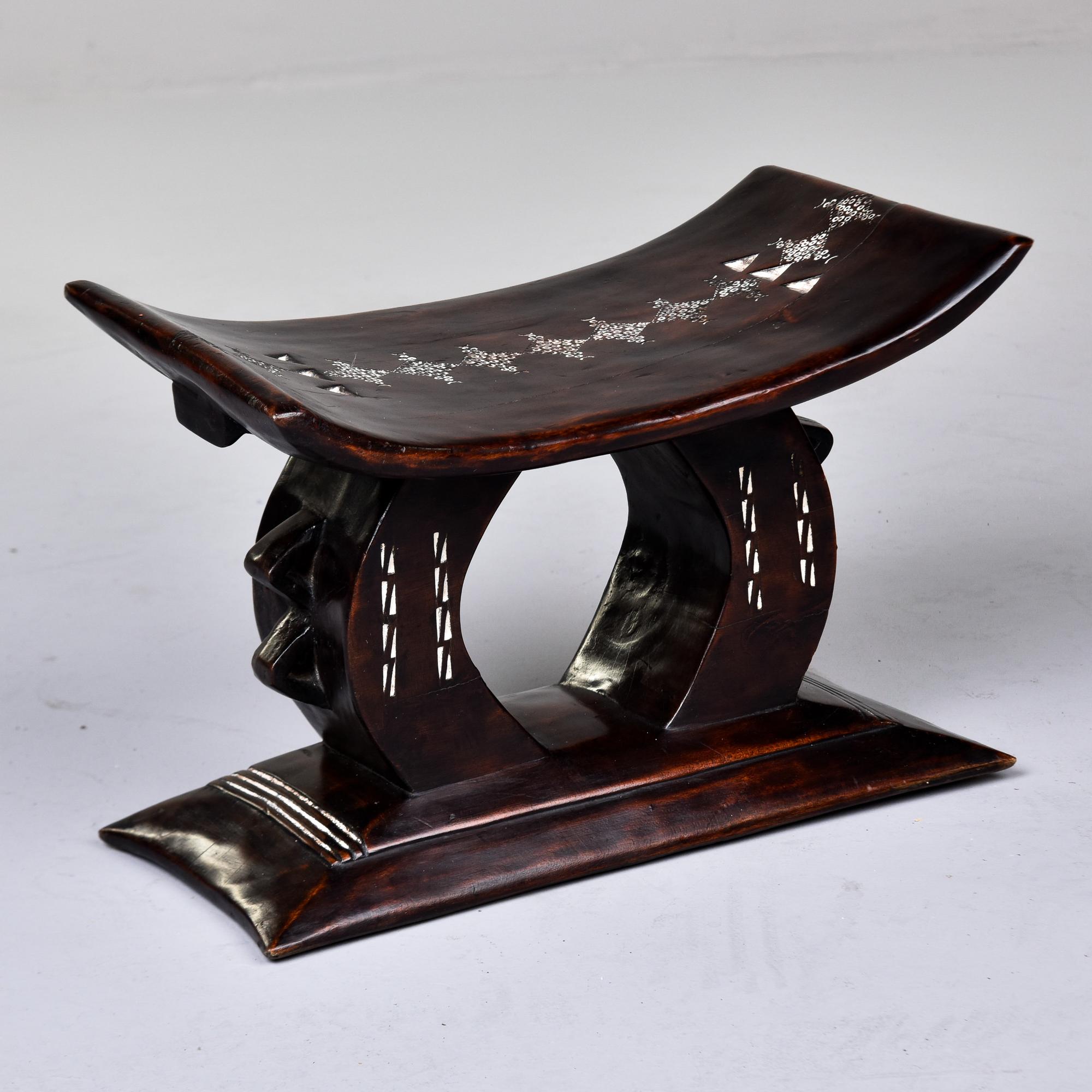 Found in Ghana, this Ashanti carved stool dates from the 1980s. Hand carved and crafted from a single piece of wood, this stool has white painted and etched detailed design on the seat and base. Unknown wood type is dense and sturdy with a dark