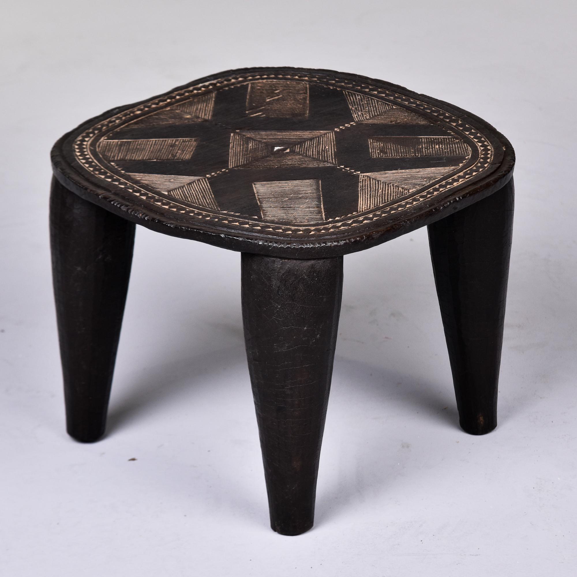  Found in Nigeria, this stool is attributed to the Nupe people of Nigeria and dates from the late 1980s / early 1990s. Hand carved from a dense, heavy wood, this stool has thick, tapered legs and an abstract, decorative pattern carved into the seat