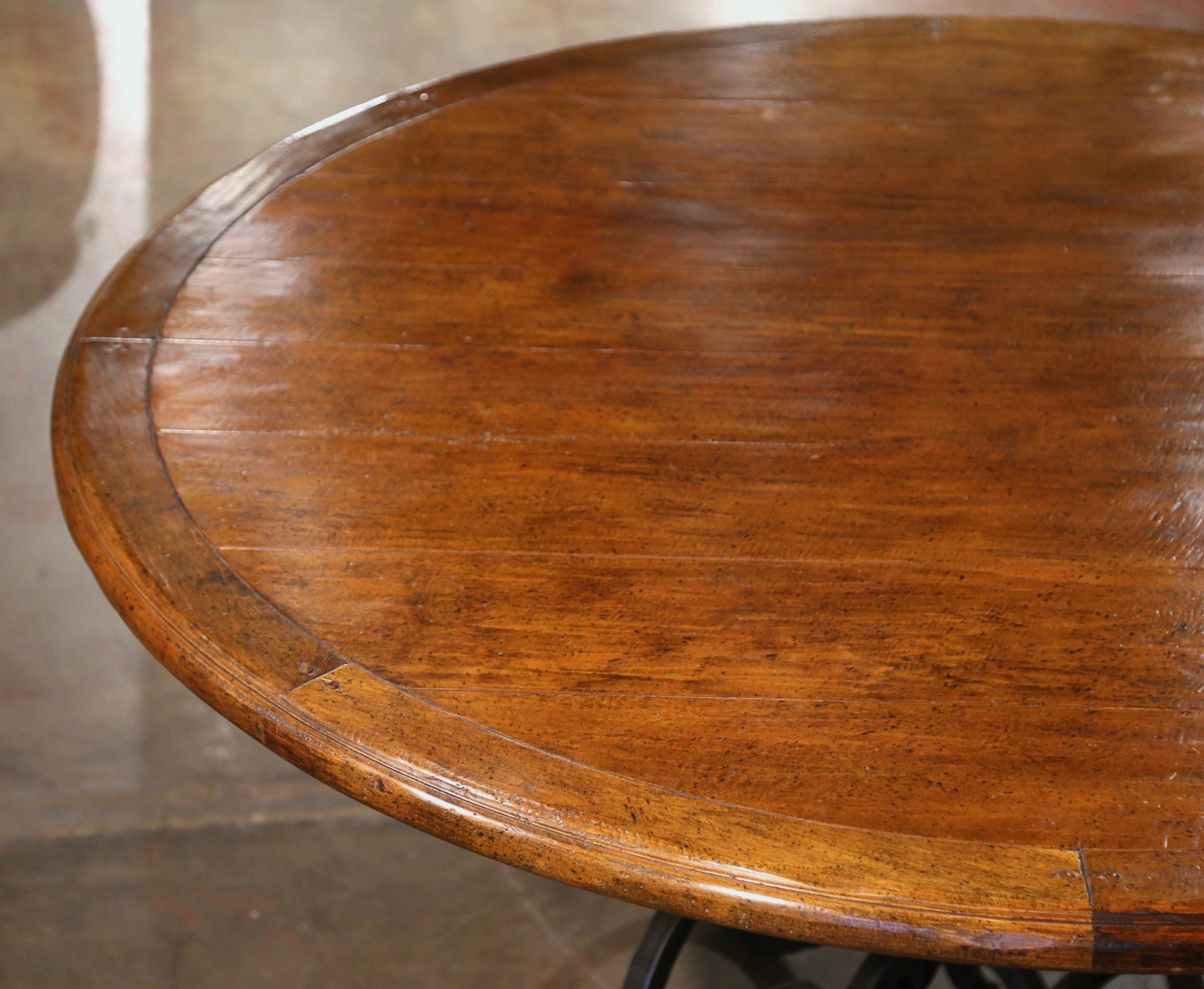 20ième siècle Table de salle à manger ronde en noyer sculpté sur base en fer forgé à quatre pieds en vente