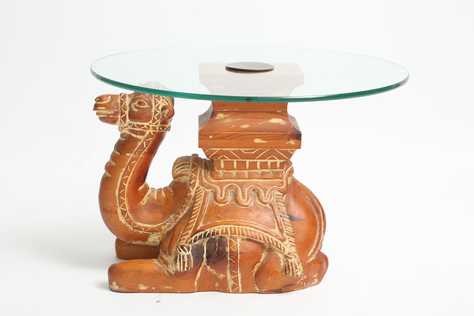 Accent table, having a round top of glass, on base of pine, carved as a well-articulated camel in recumbent pose. 

Stock ID: D2252
 