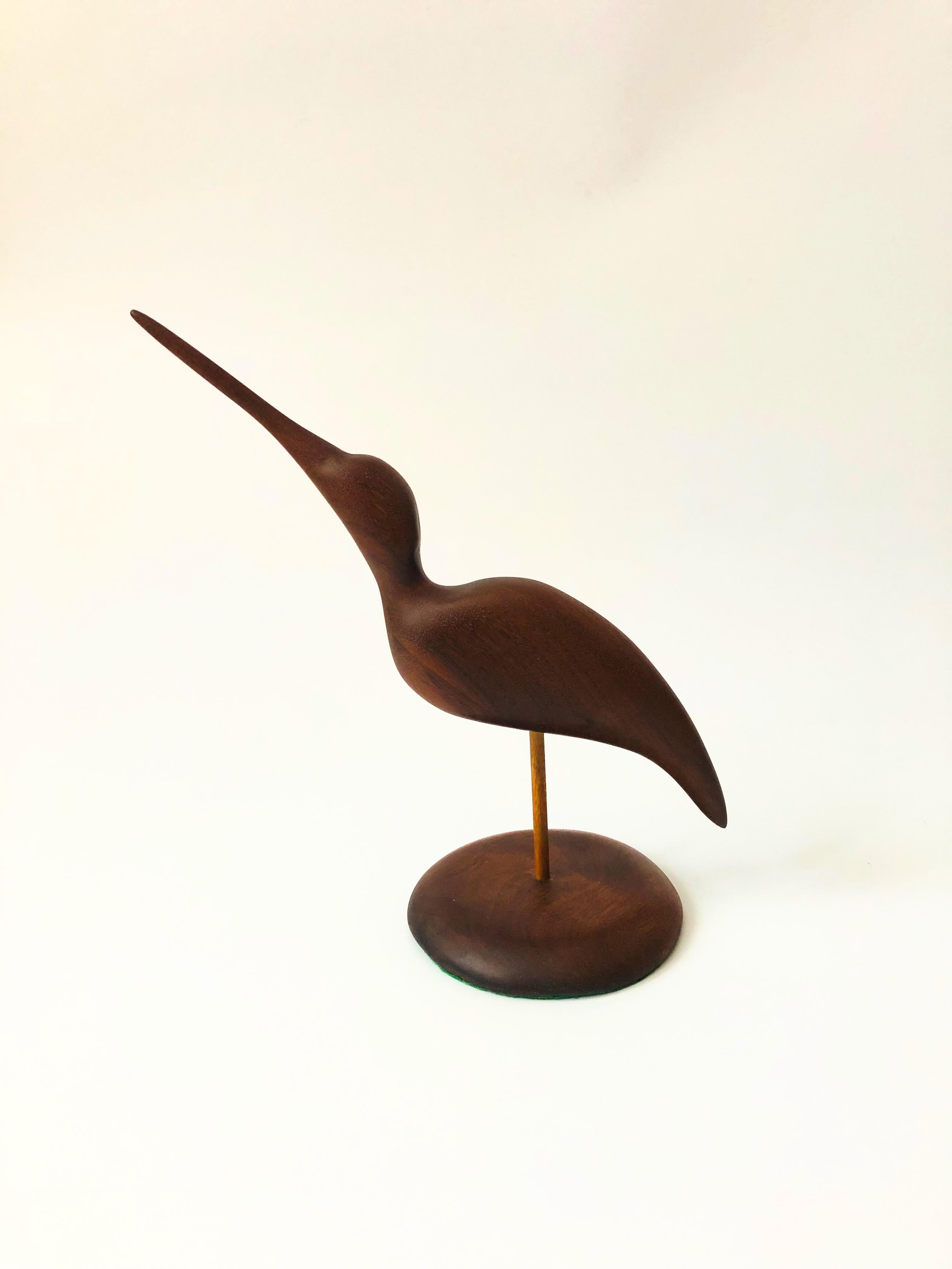 A beautiful vintage hand carved wood bird sculpture. Features a sandpiper bird, carved smooth, mounted to a circular wood base. Felted bottom.
 