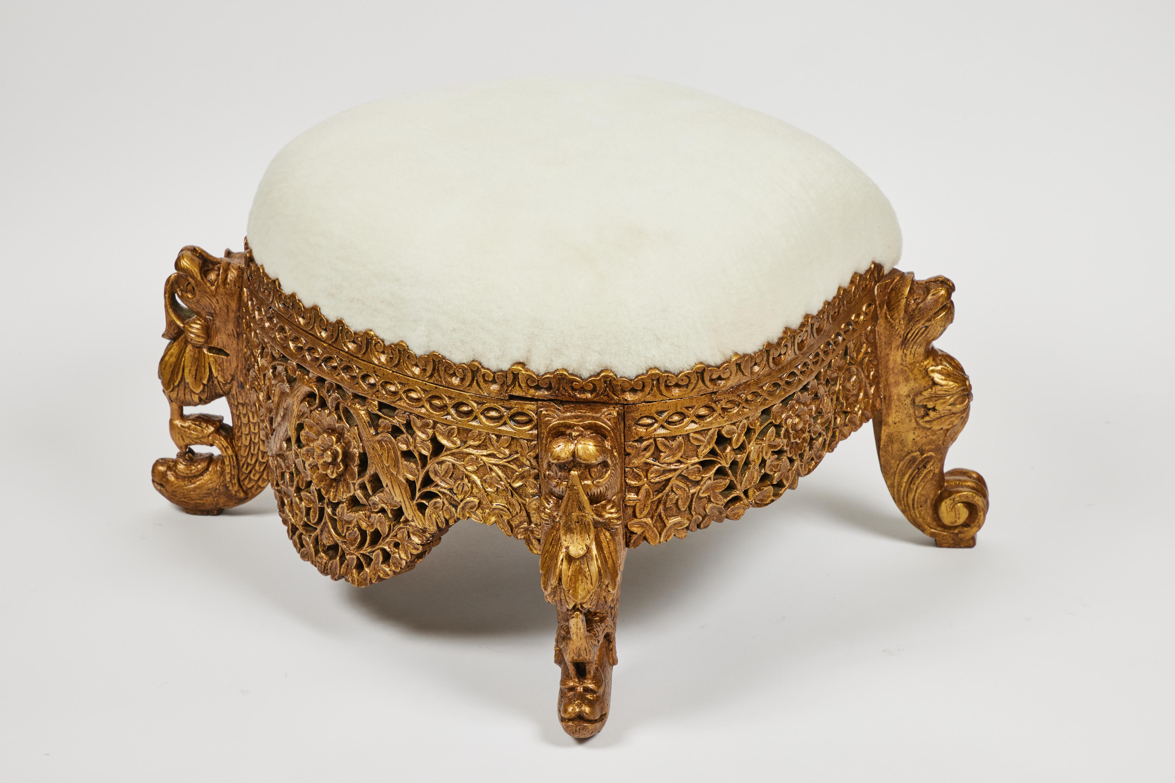 This elaborately carved wood foot stool with it's hand painted rich gold finish is newly upholstered in fluffy white shearling and 

Measures: 22.5