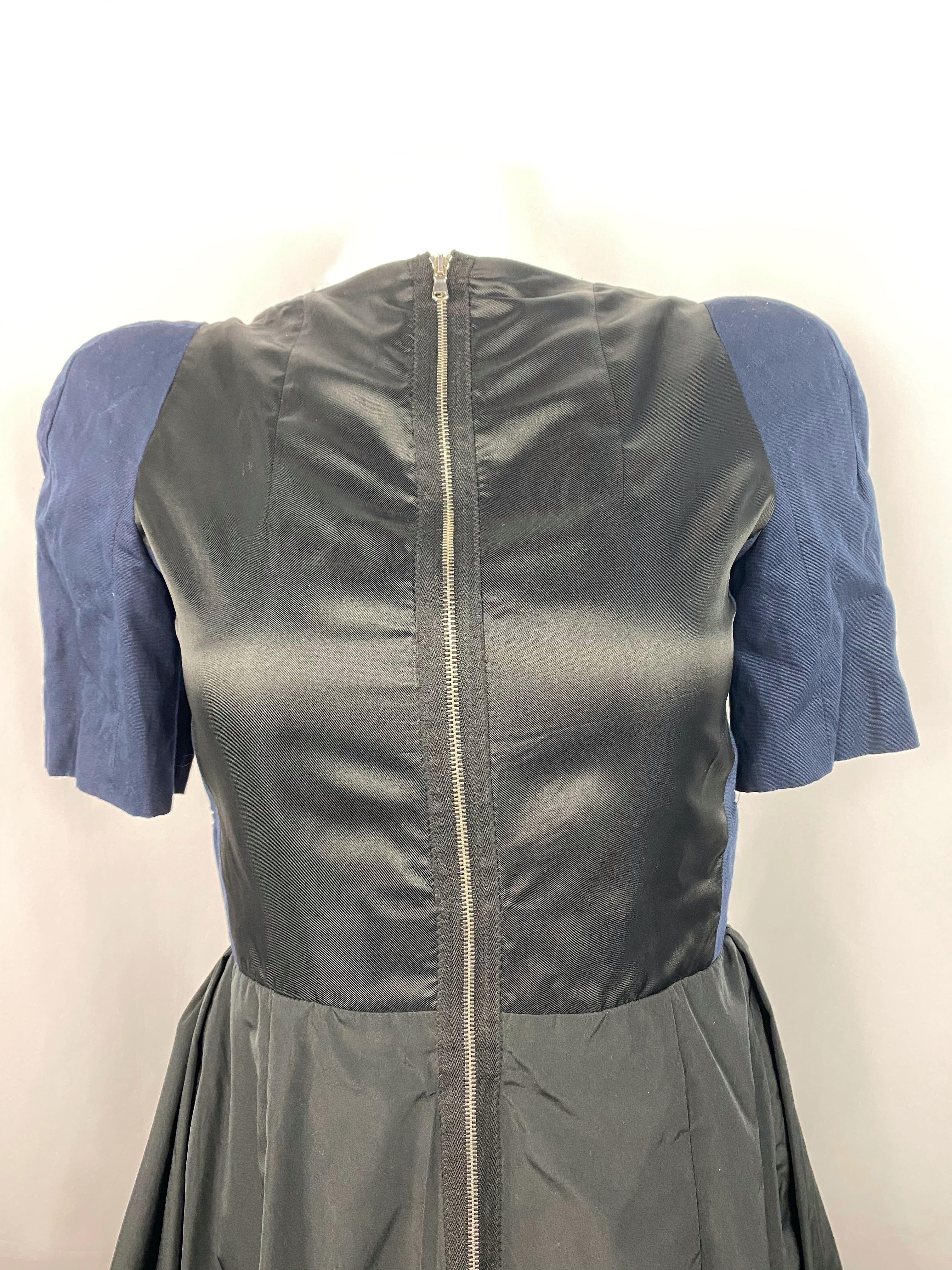Product details:
Size 40.
Featuring silver tone front zip closure, open back with rear button closure, black ruffled skirt and navy short balloon sleeves.
Made in Hungary.