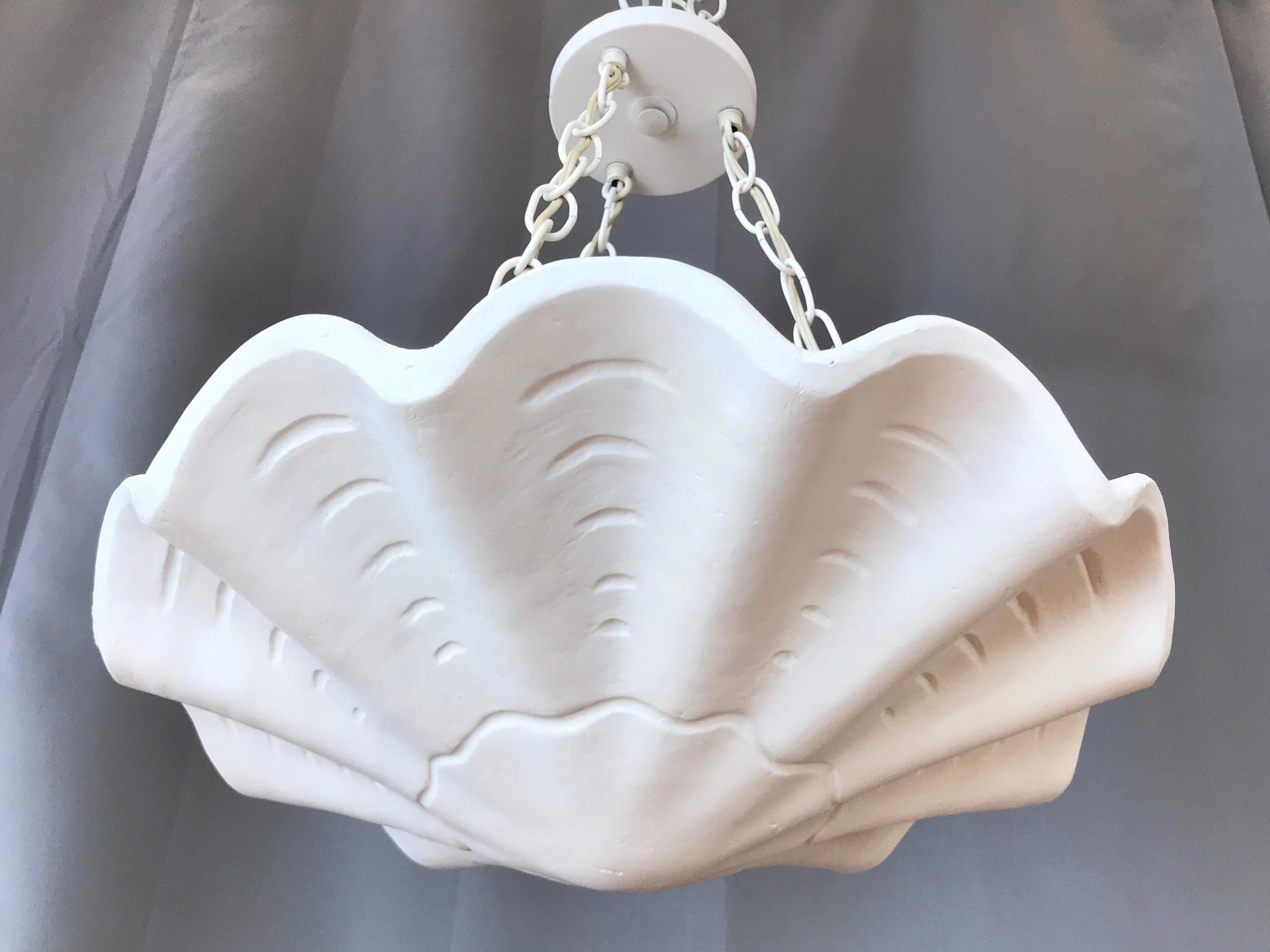 An uncommon late 1960s white scalloped plaster plafonnier by Casella Lighting.

Shell-inspired plaster pendant ceiling light with three-chain suspension and three sockets. A tastefully streamlined take on a 1940s plaster plafonnier by Frances