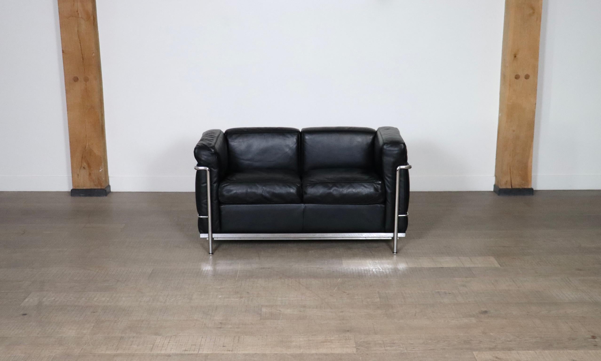 Incroyable canapé deux places LC2, un véritable classique du design de Le Corbusier, Pierre Jeanneret et Charlotte Perriand, conçu à l'origine en 1928. Le canapé moderne est composé d'un cadre tubulaire chromé et de coussins en cuir noir haut de