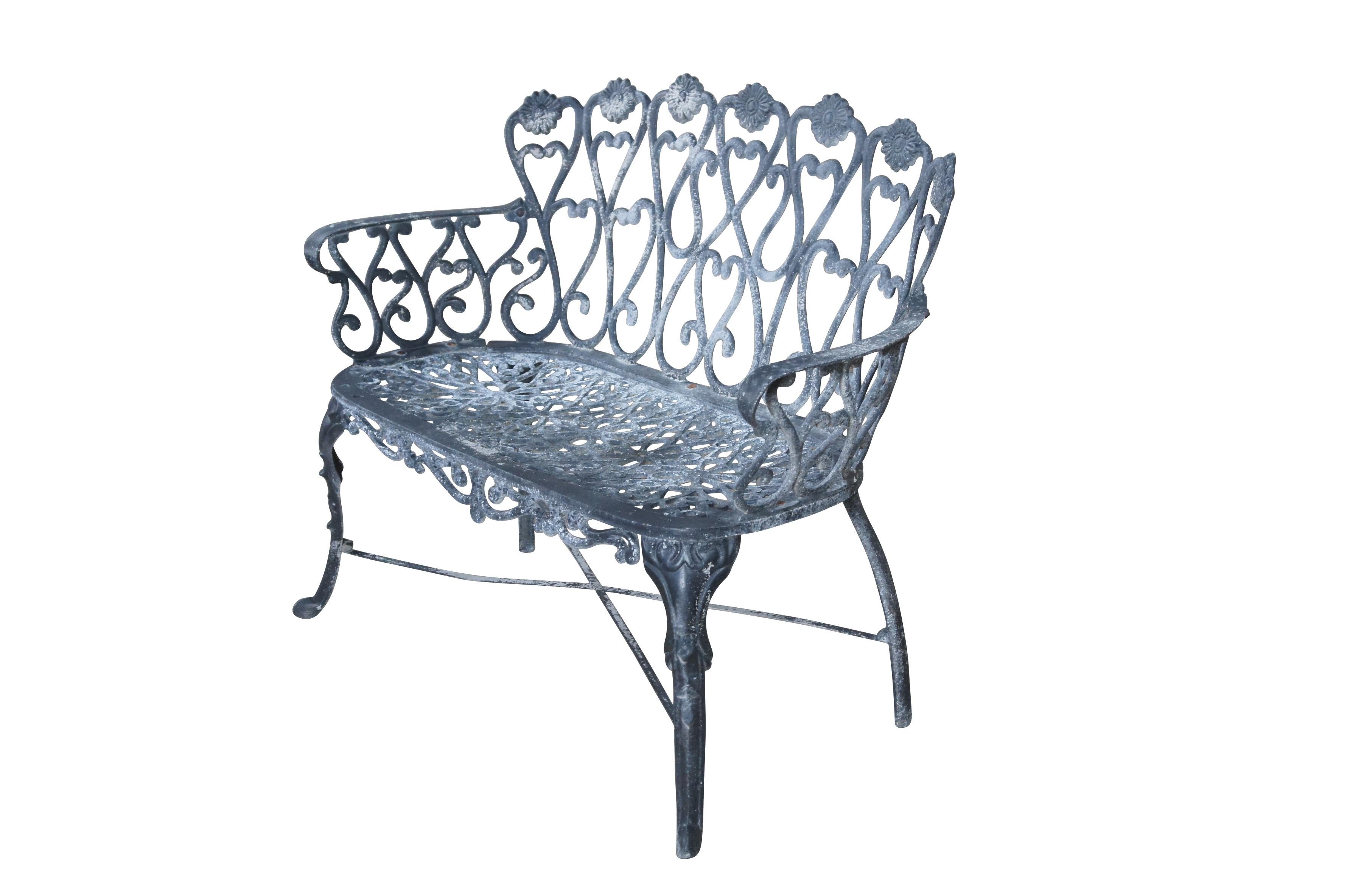 A cast aluminum outdoor garden settee with prominent scrolls, floral medallions, x-form stretcher and resting on front pad feet.

Dimensions:
41