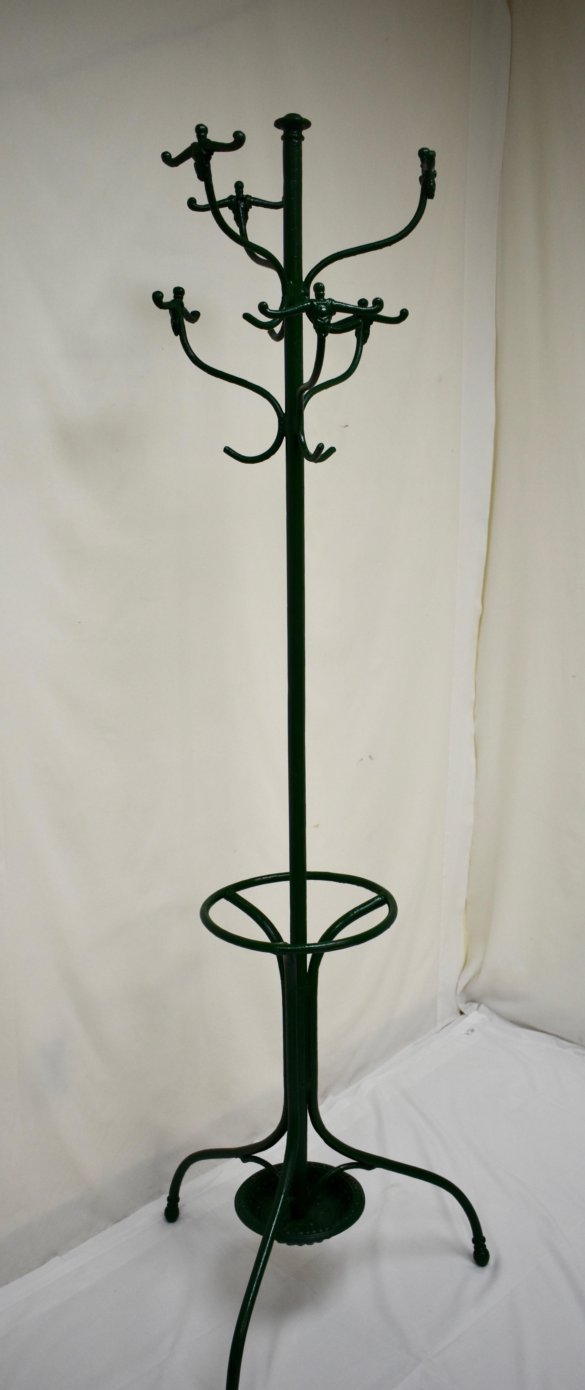This is a nice example of the classic early 20th century central European hall tree in wrought and cast iron. It features the usual anthropomorphic double hooks with single hooks trailing and a circular umbrella stand and drip tray. Recently