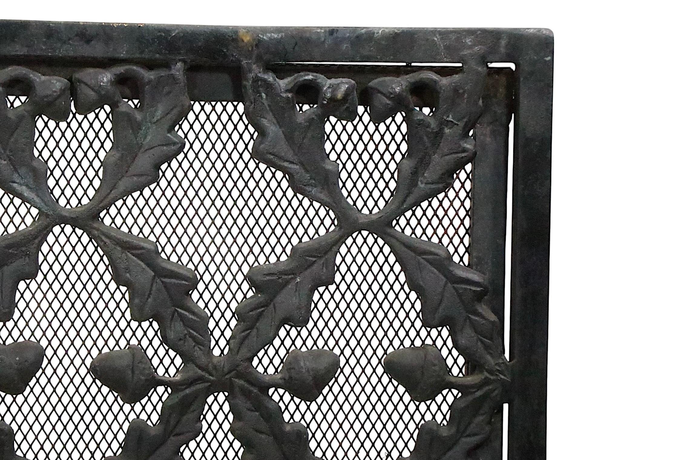 Paravento per camino fisso in ottone e ferro di alta qualità, realizzato in Francia intorno al XX secolo. Il paravento presenta un frontale decorativo in ottone fuso a forma di ghiande e foglie.  a maglie di catena, fissate a un telaio in ottone