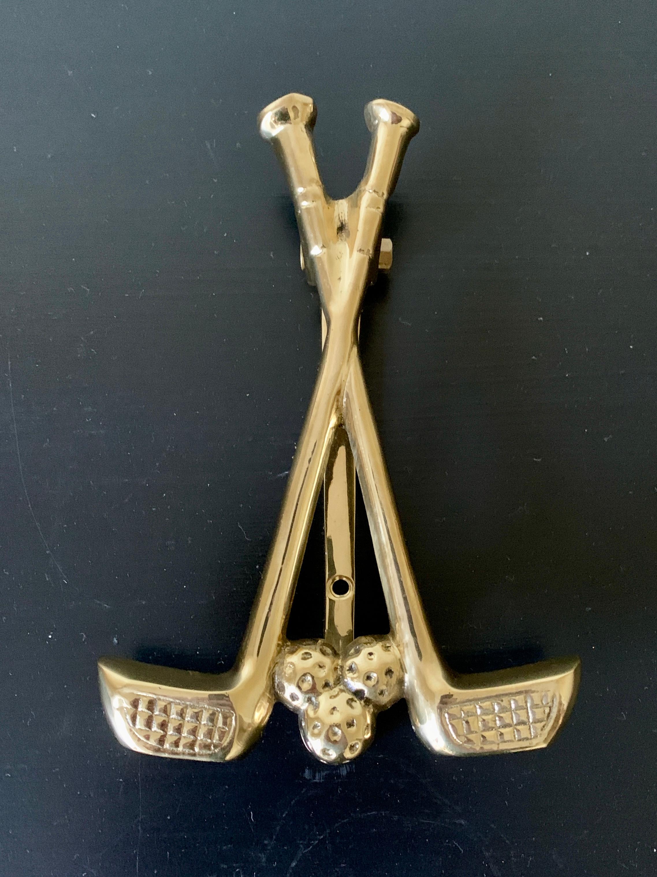 A beautiful cast brass door knocker in the form of two golf clubs and a golf balls.

USA, Mid-20th Century

Measures: 4.5
