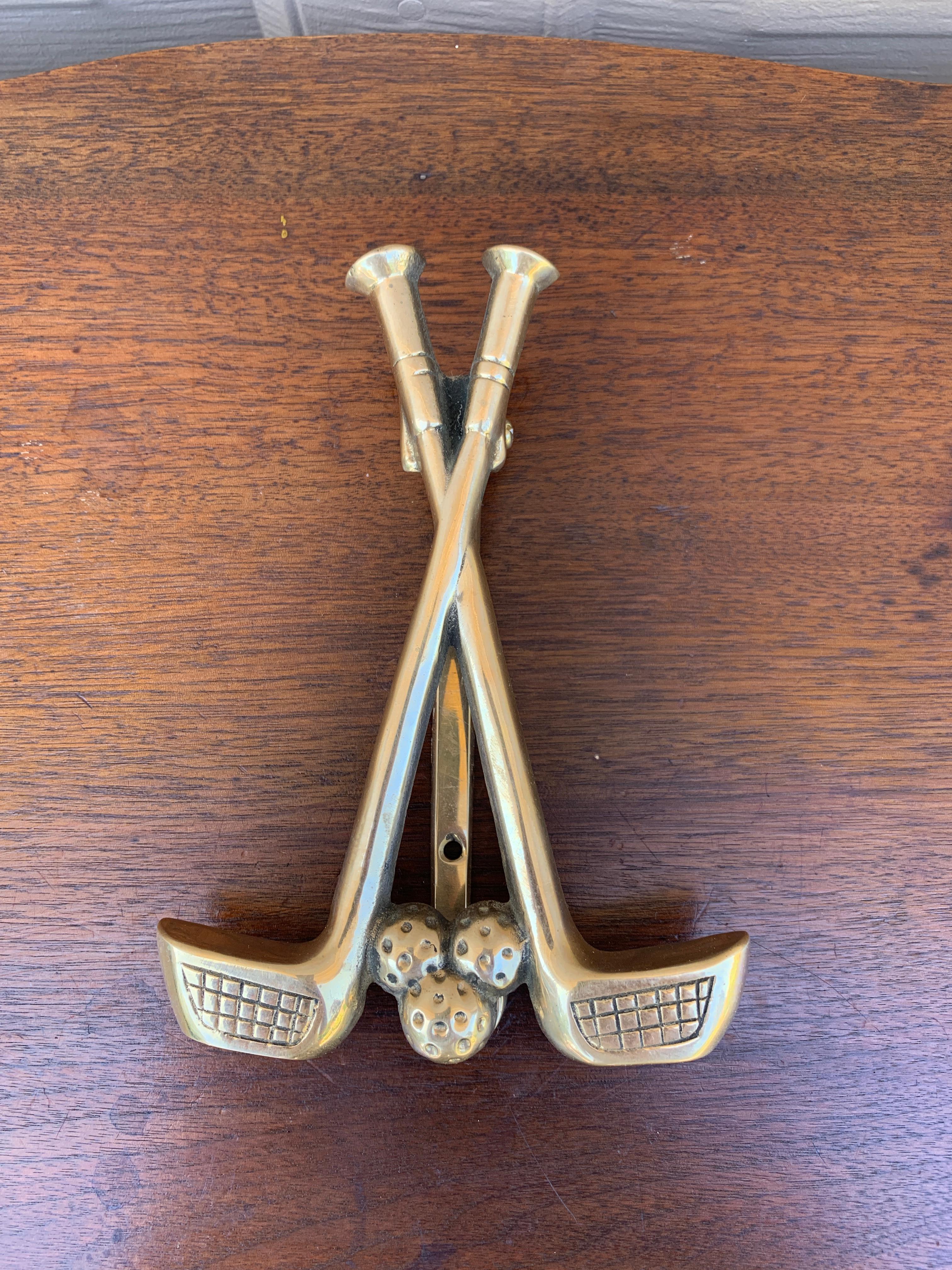 Magnifique heurtoir de porte en laiton moulé, en forme de deux clubs de golf et d'une balle de golf.

USA, Milieu du 20ème siècle

Mesures : 4,75 