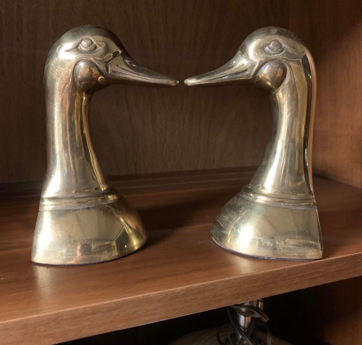 A Classic pair of vintage brass bookends, a pair of duck heads. Made in Korea likely during the 1960s or 1970s. The bookends are not lacquered allowing a rich patina to show with age.
