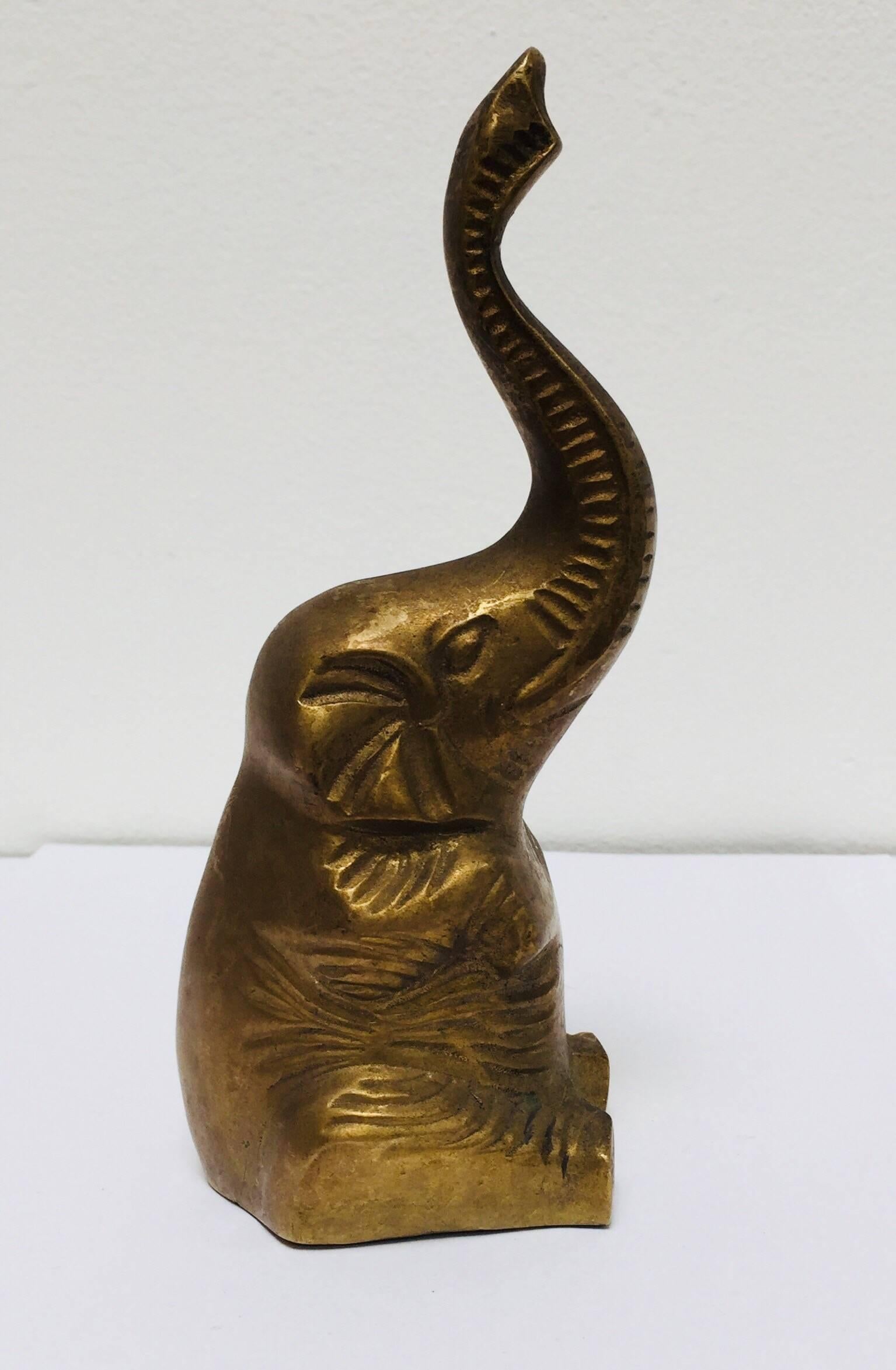 Vintage cast solid polished brass elephant sculpture paper weight.
The elephant is seated and a trunk is up for good luck. 
Lots of detail on the front and sides of the elephant.
Dimensions: 2.75