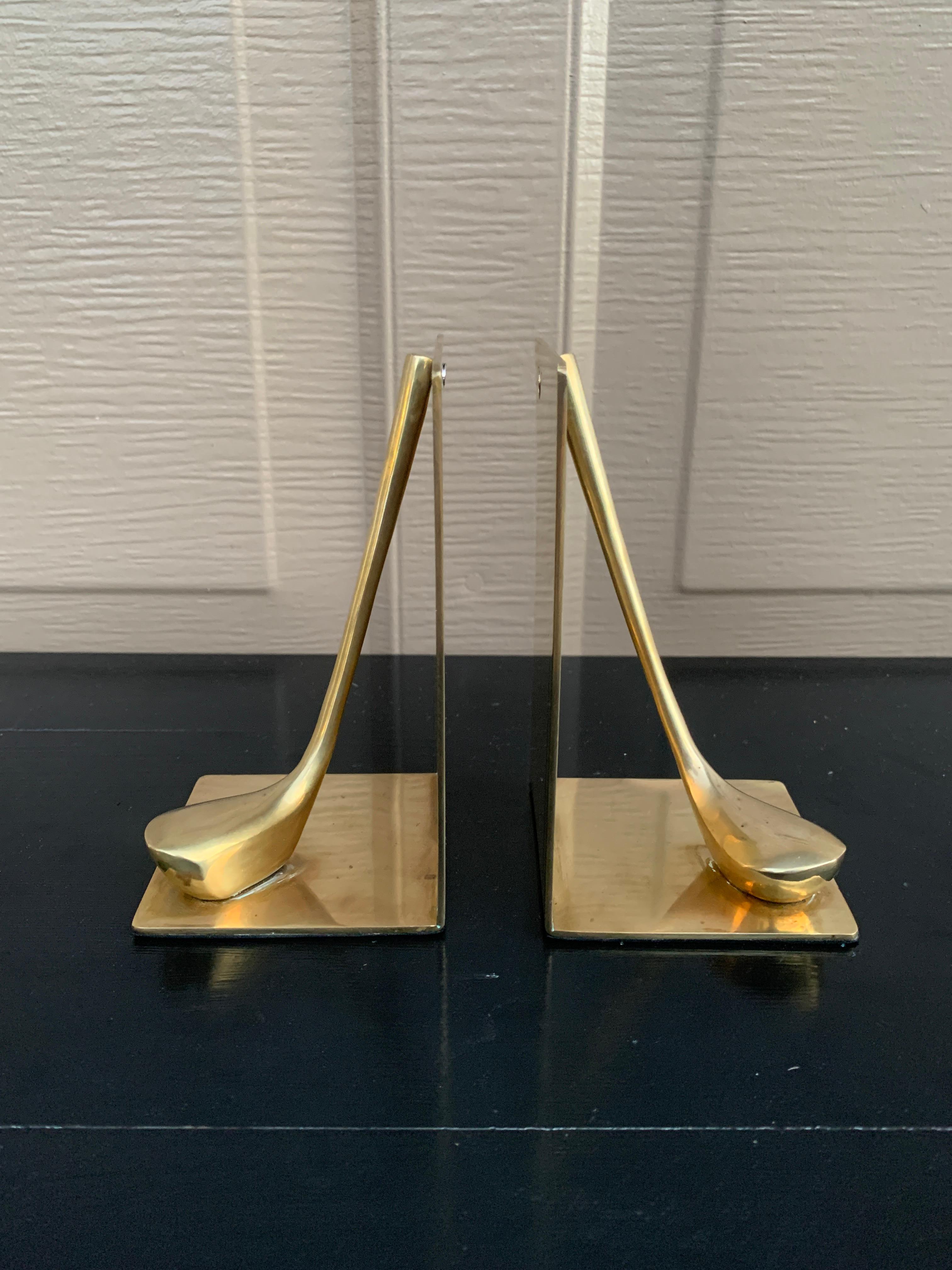 Une belle paire de serre-livres en laiton moulé en forme de clubs et de balles de golf.

Circa 1980

Mesures : 3 