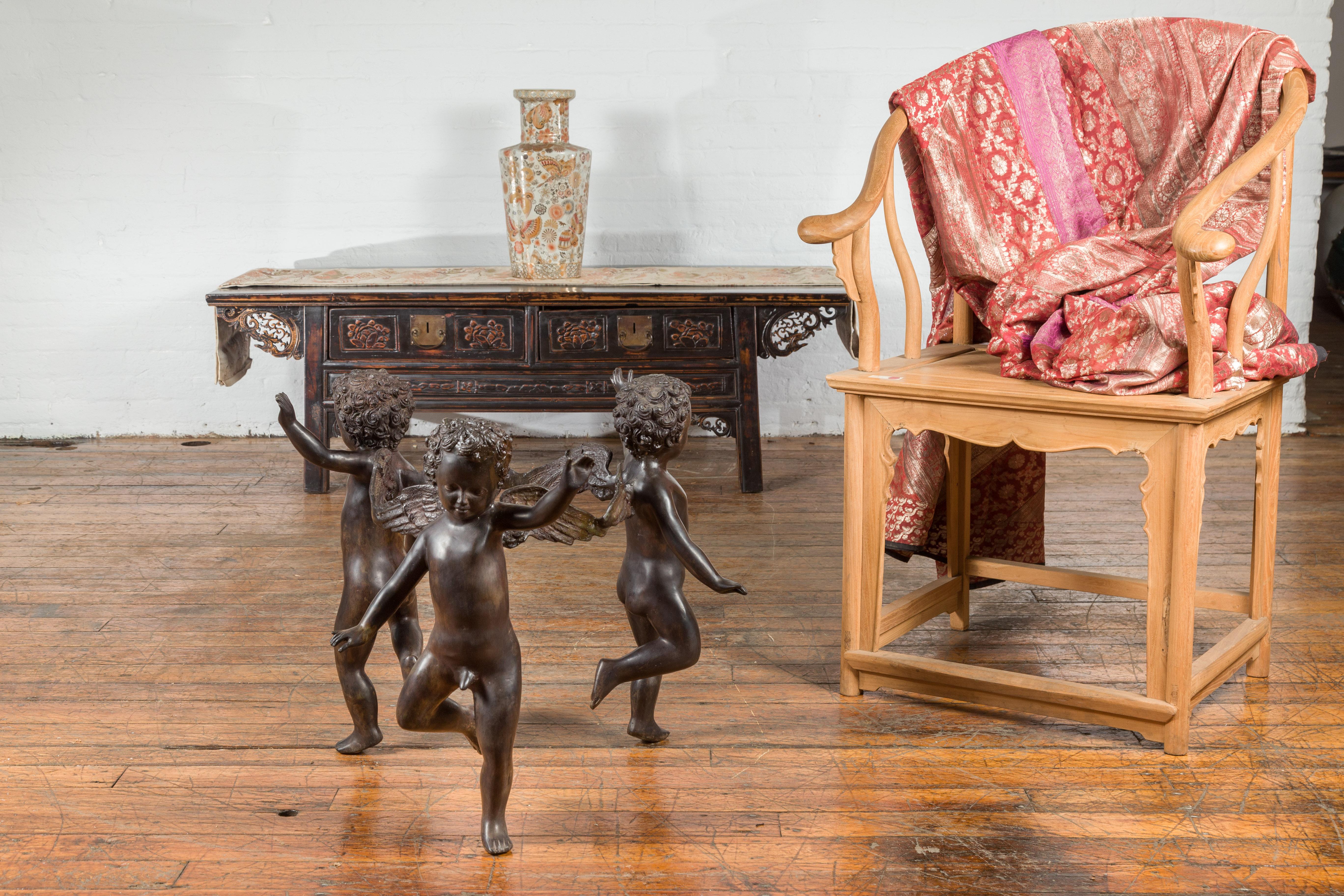 A vintage lost wax bronze dancing cherubs coffee table base from the mid 20th century, with dark patina. We have two table bases available, priced and sold $1,500 each. Created with the traditional technique of the lost-wax (à la cire Perdue) that